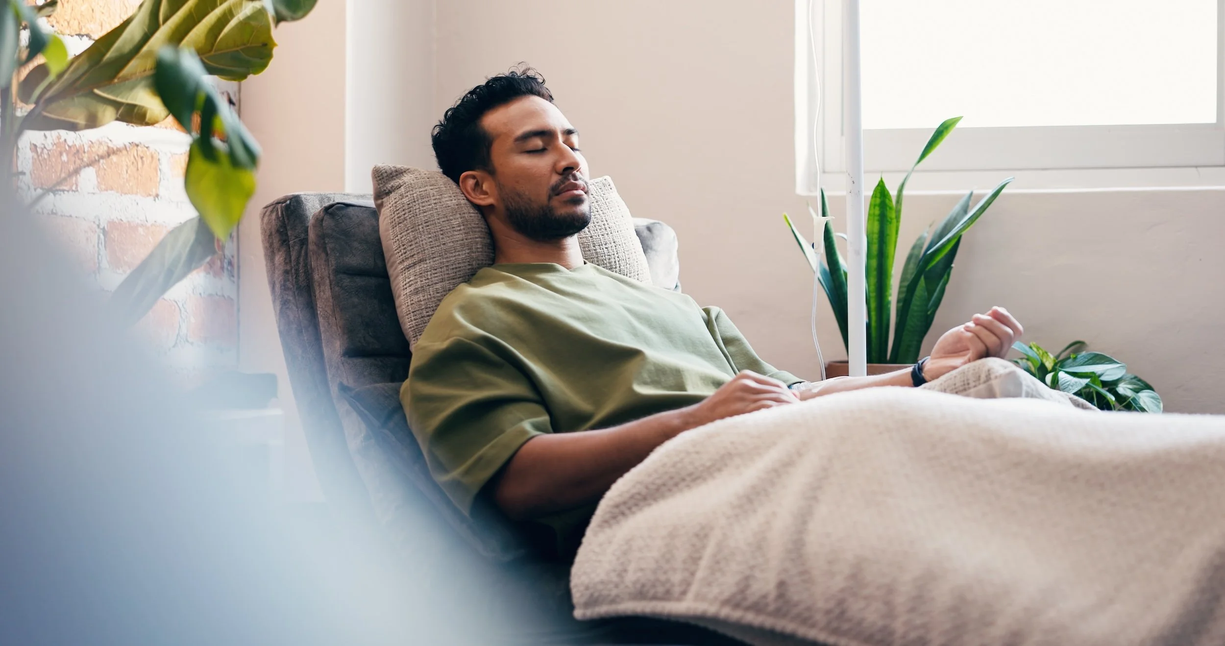 Man receiving an IV drip in a lounge