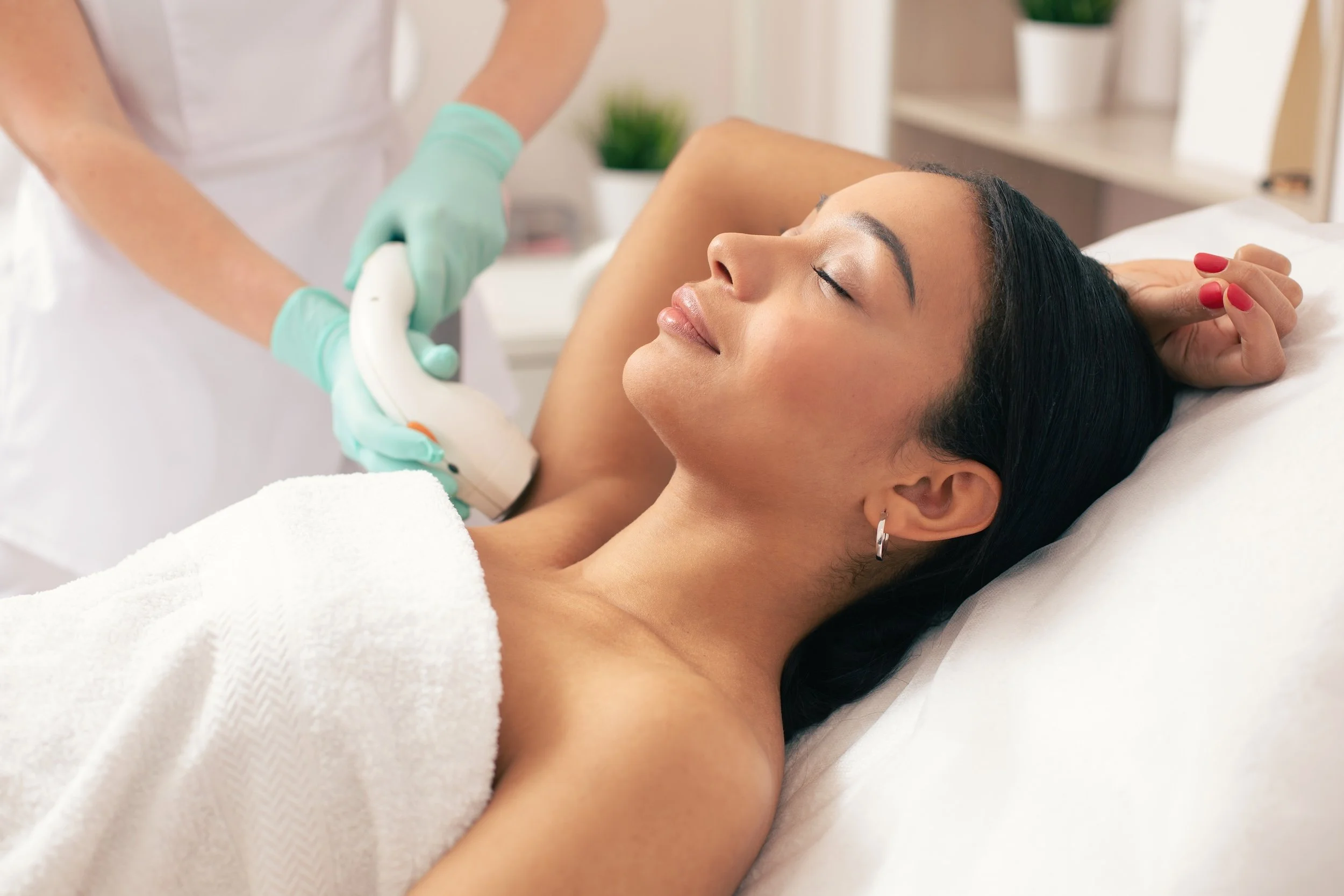 Woman receiving a hair removal treatment on her armpit in a medspa