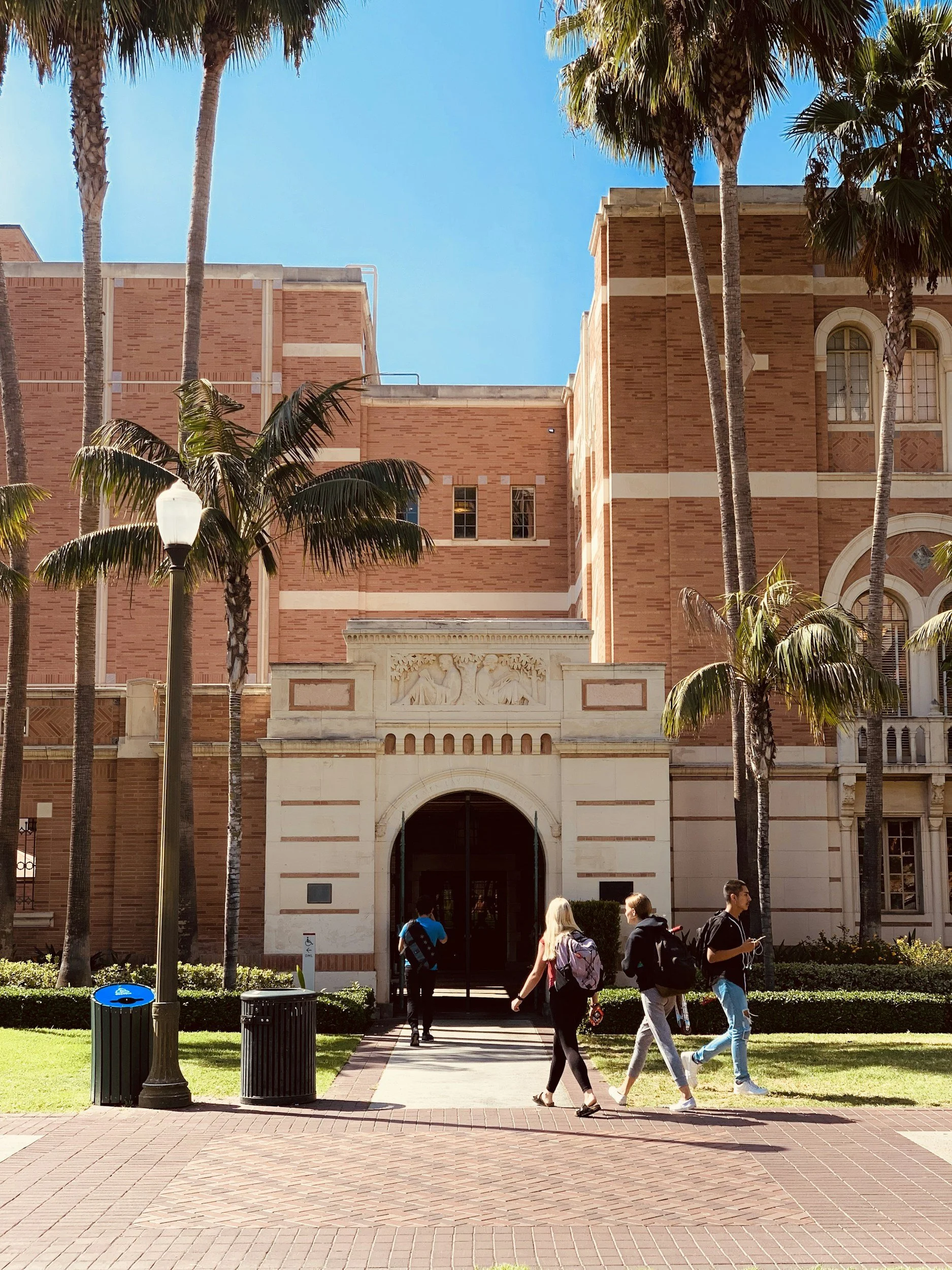 Sunny Los Angeles school campus with palm trees and students walking toward the entrance – representing the local schools and nonprofits VibeCheckCo serves across LA County.