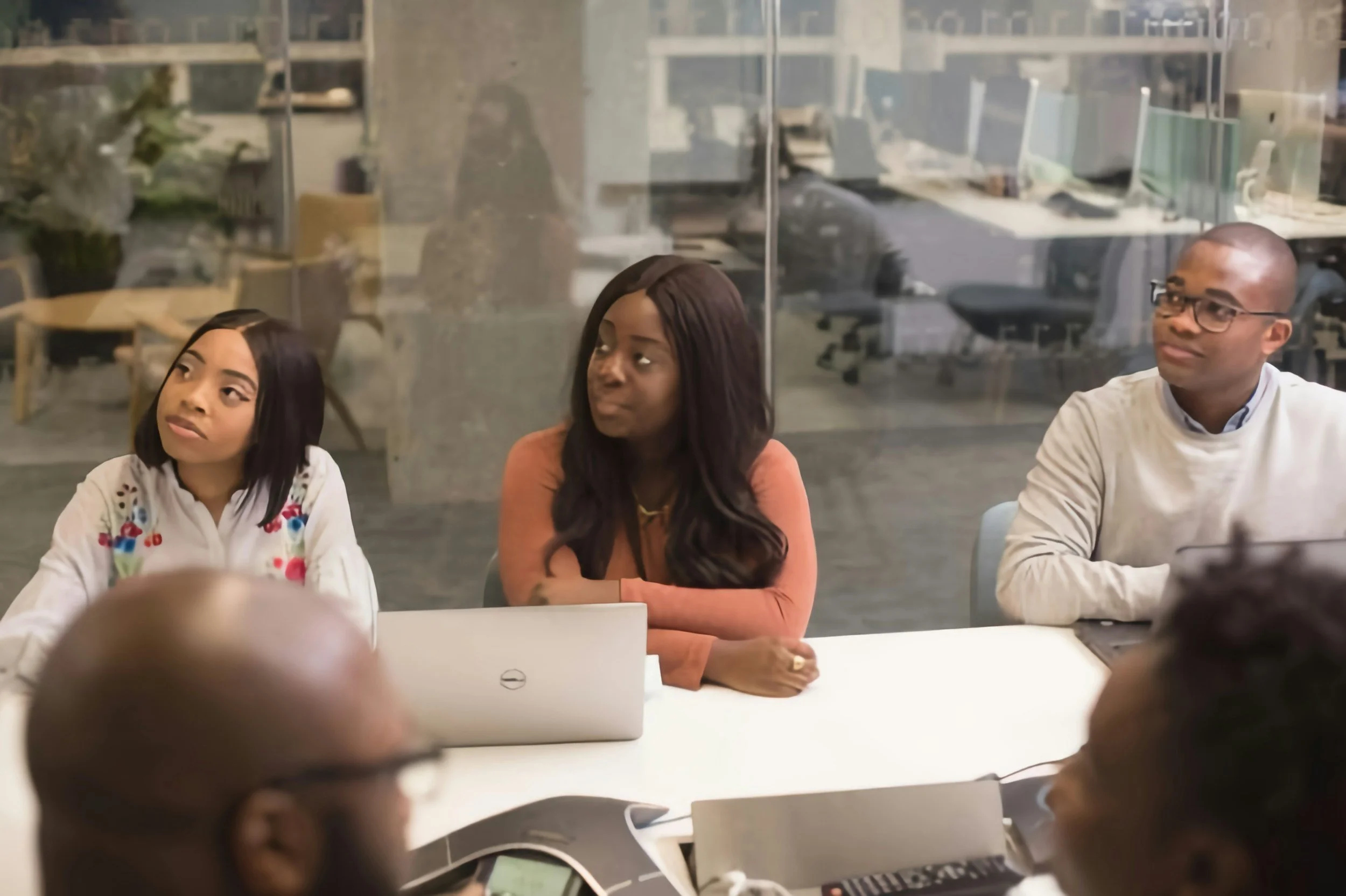 Diverse group of professionals in a collaborative meeting around a conference table with laptops – representing the discovery calls and customized support VibeCheckCo provides for schools and nonprofits in Los Angeles.