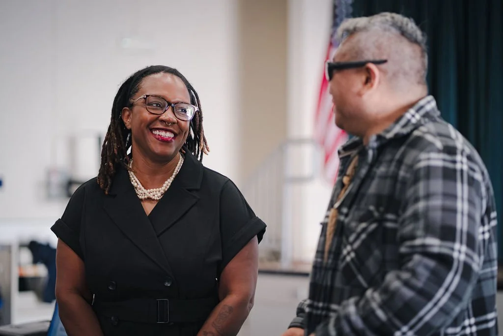 Dr. Clarece Weinraub smiling warmly while in conversation with a colleague – representing the judgment-free, human-first approach she brings to culture work with schools and nonprofits in Los Angeles.