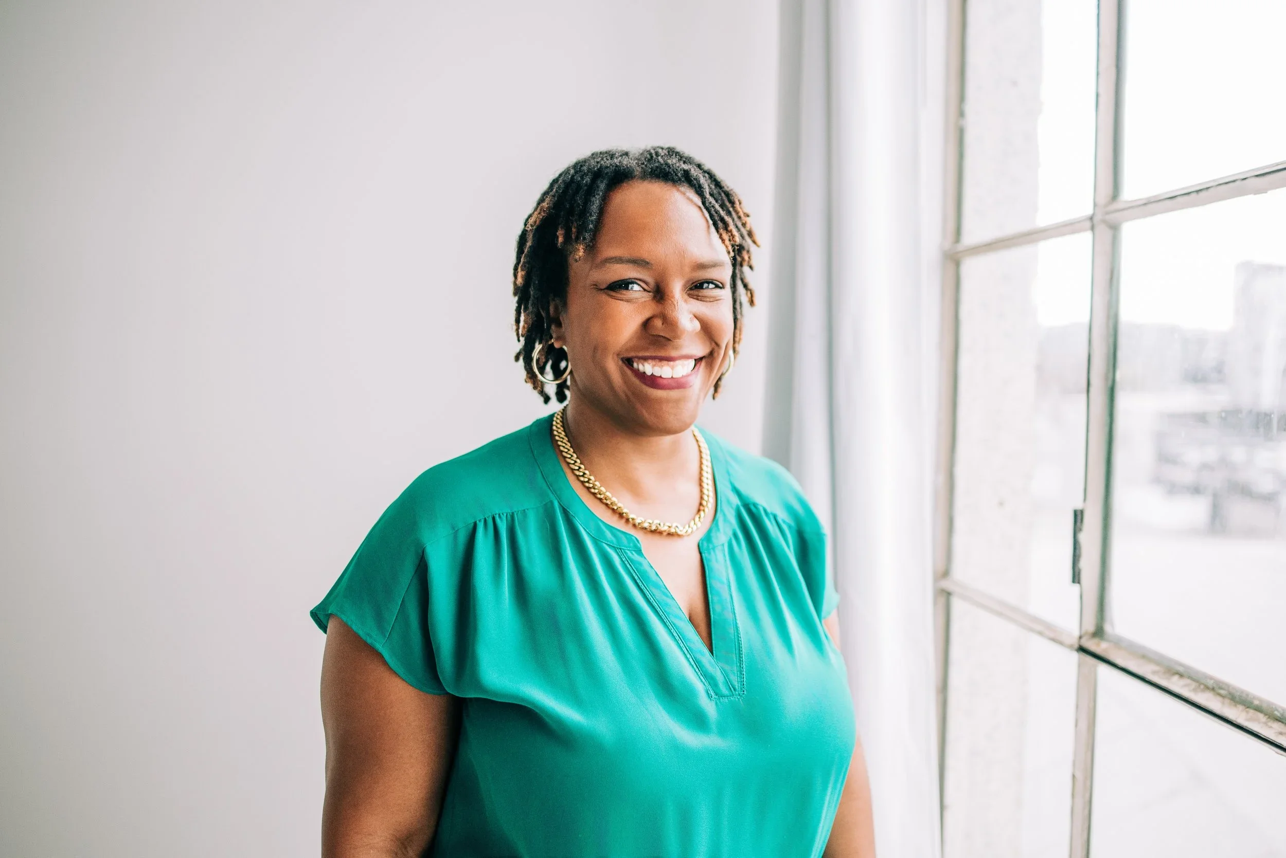 Dr. Clarece Weinraub, Founder of VibeCheckCo, smiling in her teal top – culture consultant helping Los Angeles schools and nonprofits