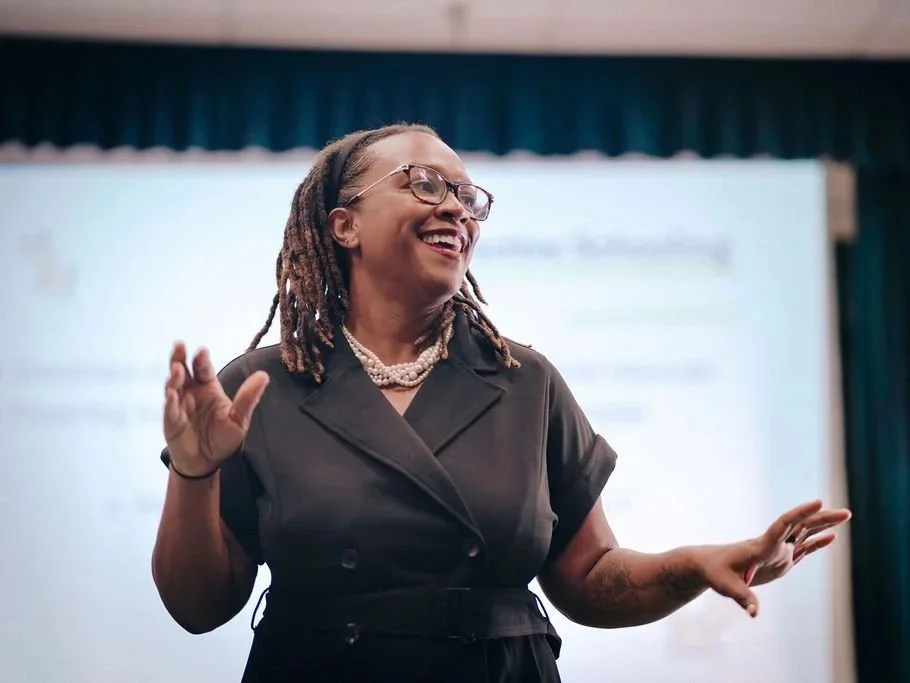 Dr. Clarece Weinraub speaking and smiling warmly during a presentation – Founder of VibeCheckCo, culture consultant helping Los Angeles schools and nonprofits.