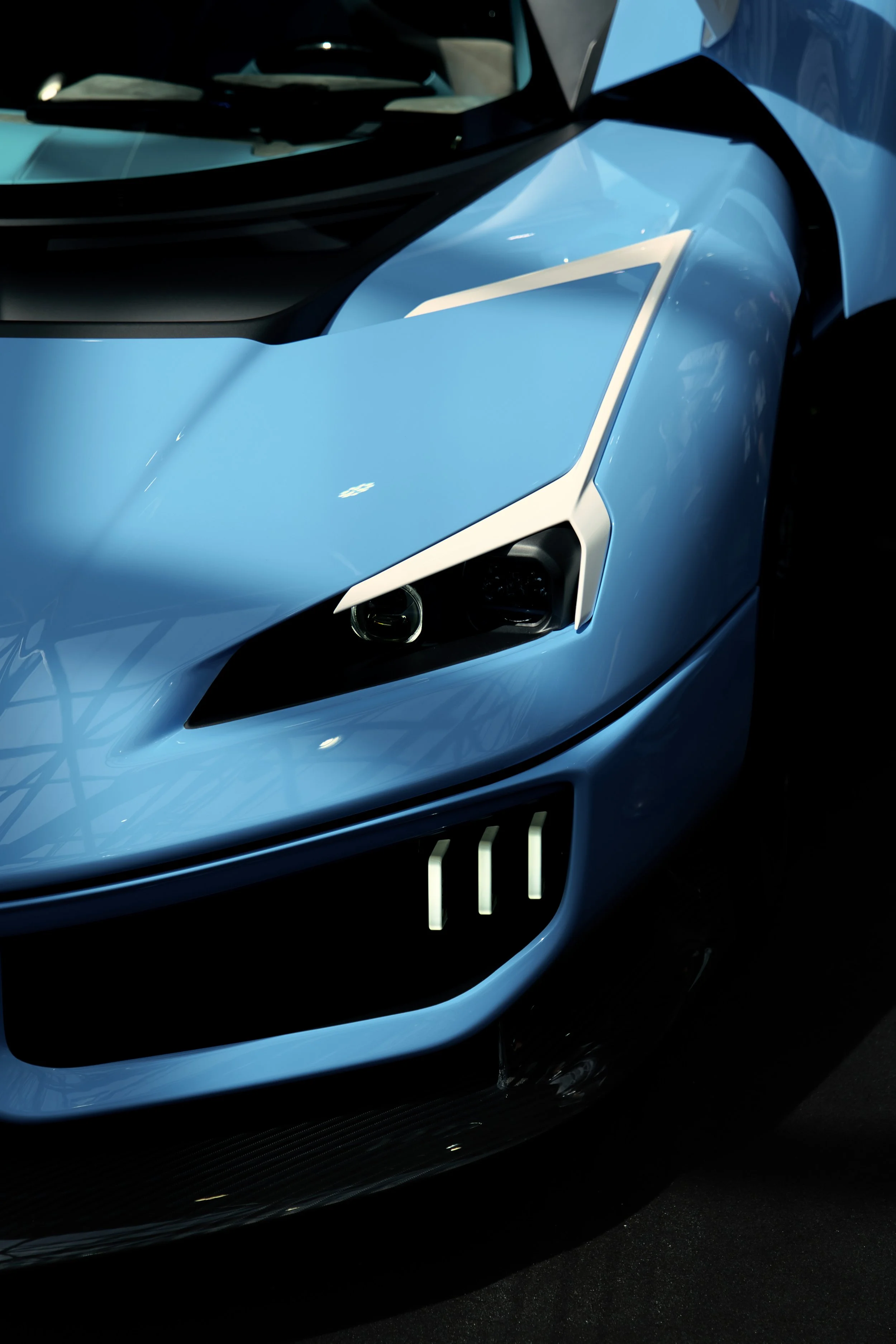 Une voiture de sport bleue avec des phares modernes et un design aérodynamique.