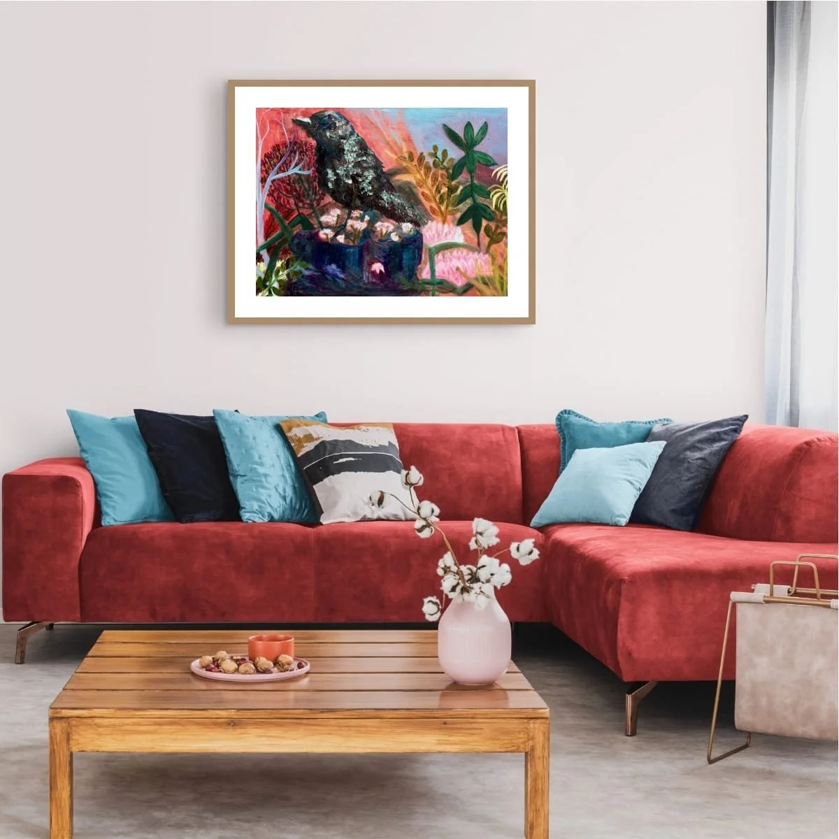 Magic Landing large format print in a gold frame with white matt boardd above a vivid red couch in a stylish living room interior.