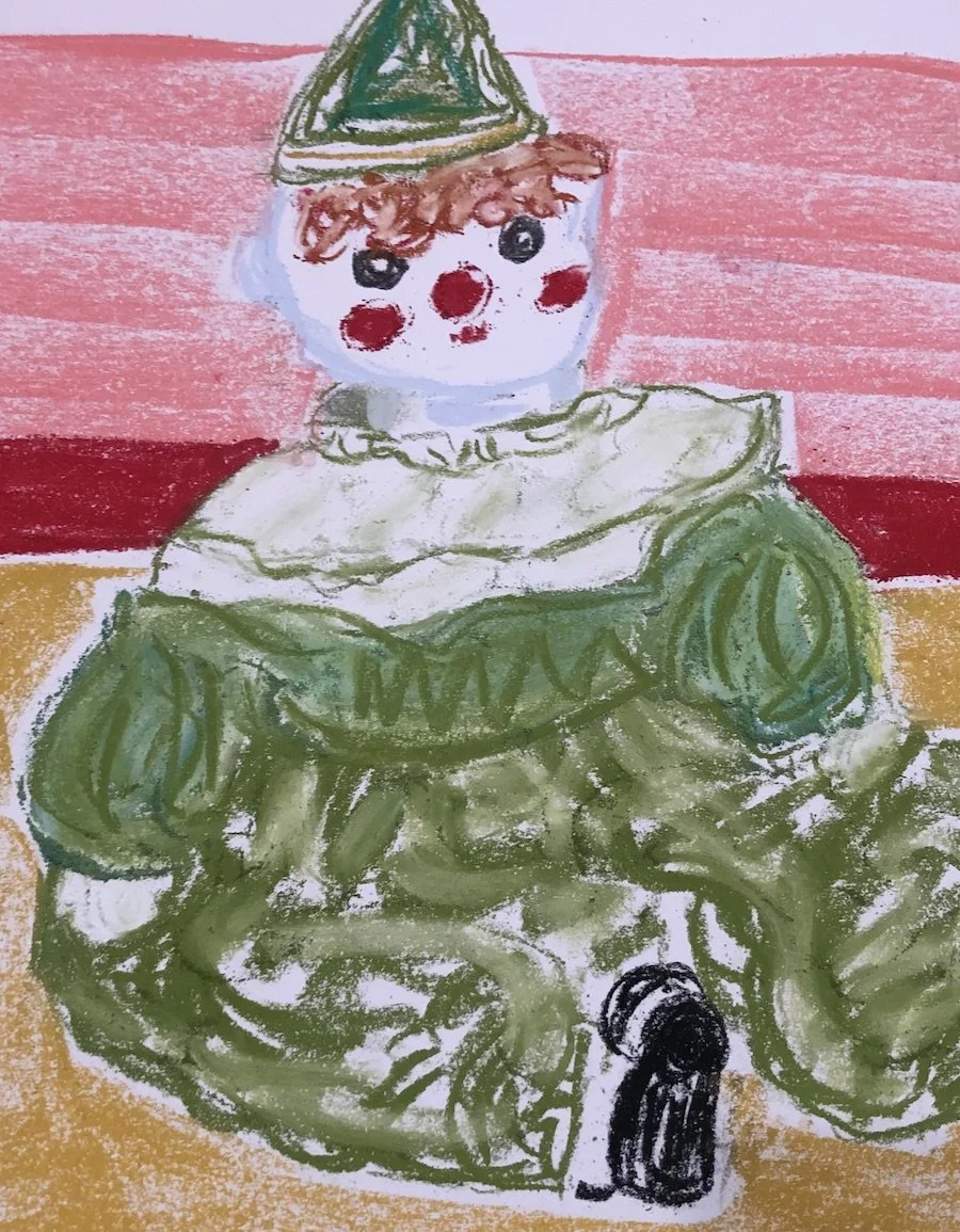 Child's drawing of a figure with a clown face, green outfit, and a party hat, sitting on a yellow and brown surface with pink and red background.