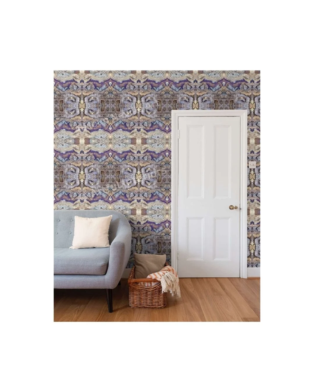 Mineral wallpaper repeat by Artful Weave  in a living room — abstract organic forms in violet, stone, gold and pale blue covering the full wall behind a grey sofa and white door.