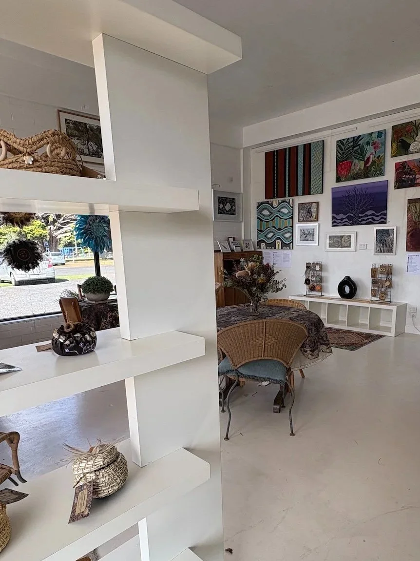 Interior of an art gallery with shelves, artwork, and furniture.