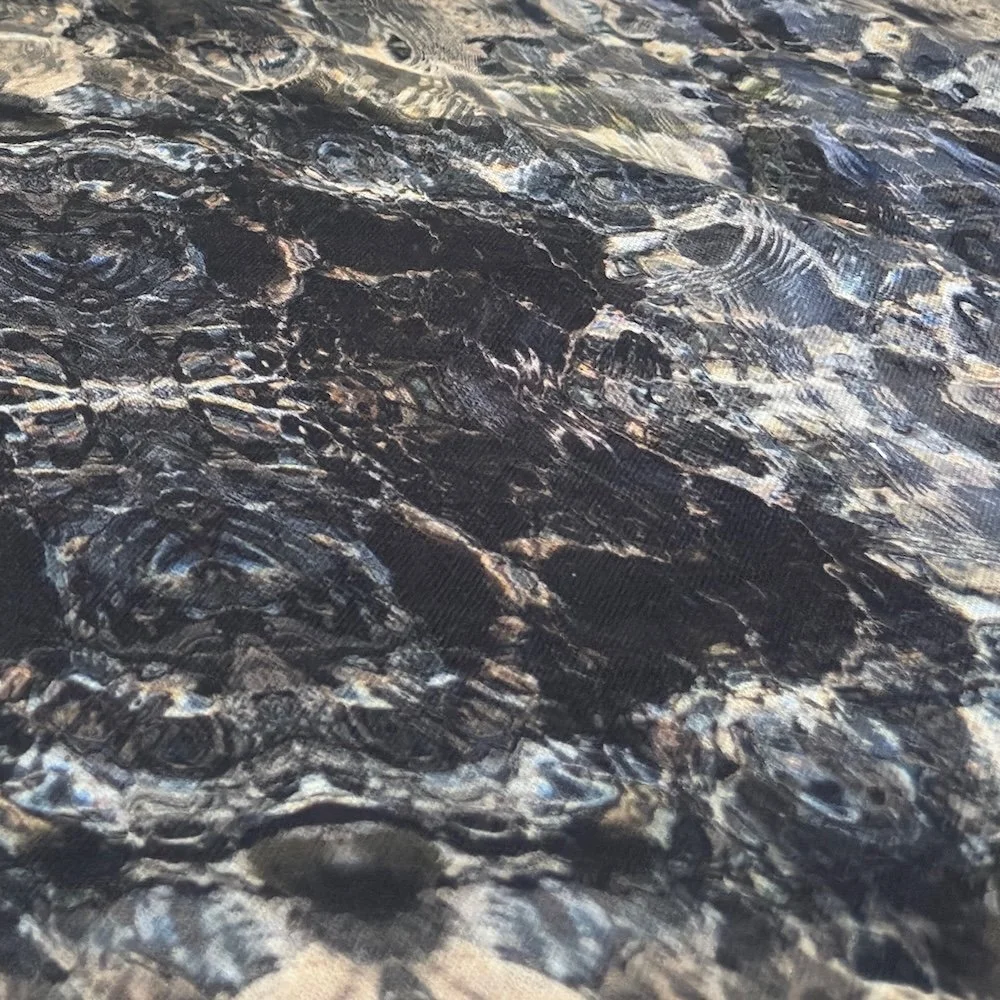 Close detail of Blue Diamond fabric pattern of tidal water showing depth and texture of the slate and cream tonal surface.