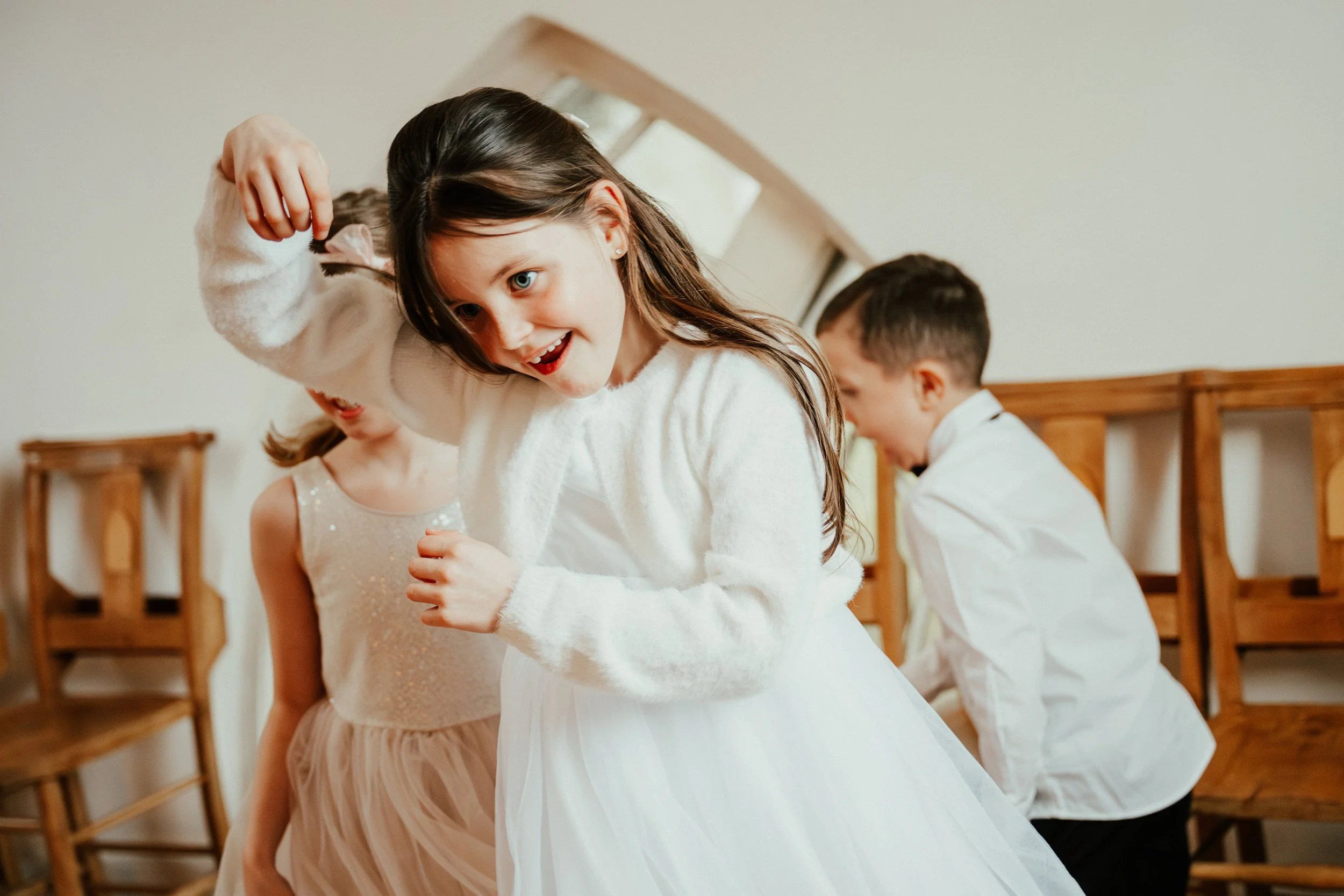 Children celebrating, some dancing and having fun indoors.