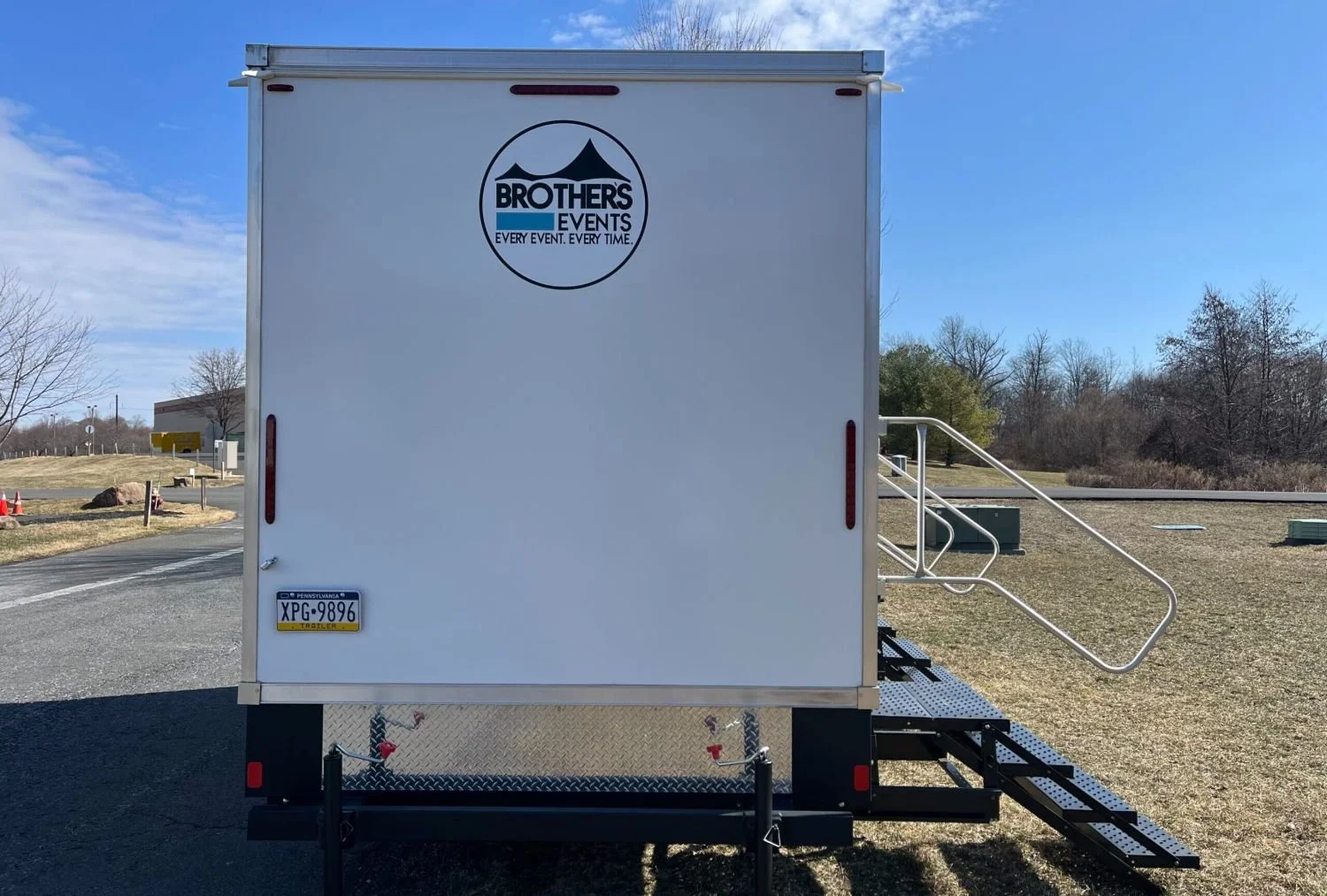 White event trailer with 'Brothers Events' logo on the back, Pennsylvania license plate, and a metal staircase leading to the side.