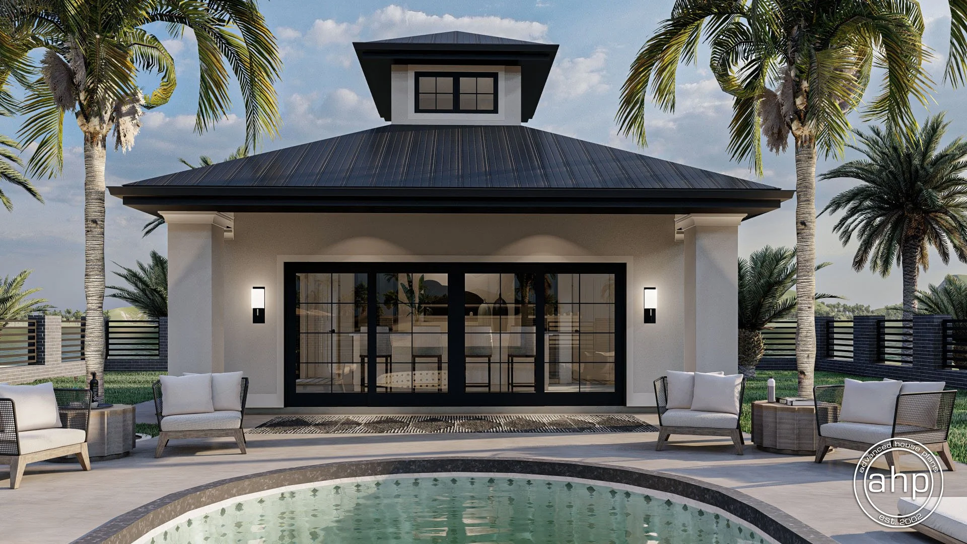 Modern backyard with a pool, outdoor seating, palm trees, and a small house with sliding glass doors and a black metal roof, under a partly cloudy sky.
