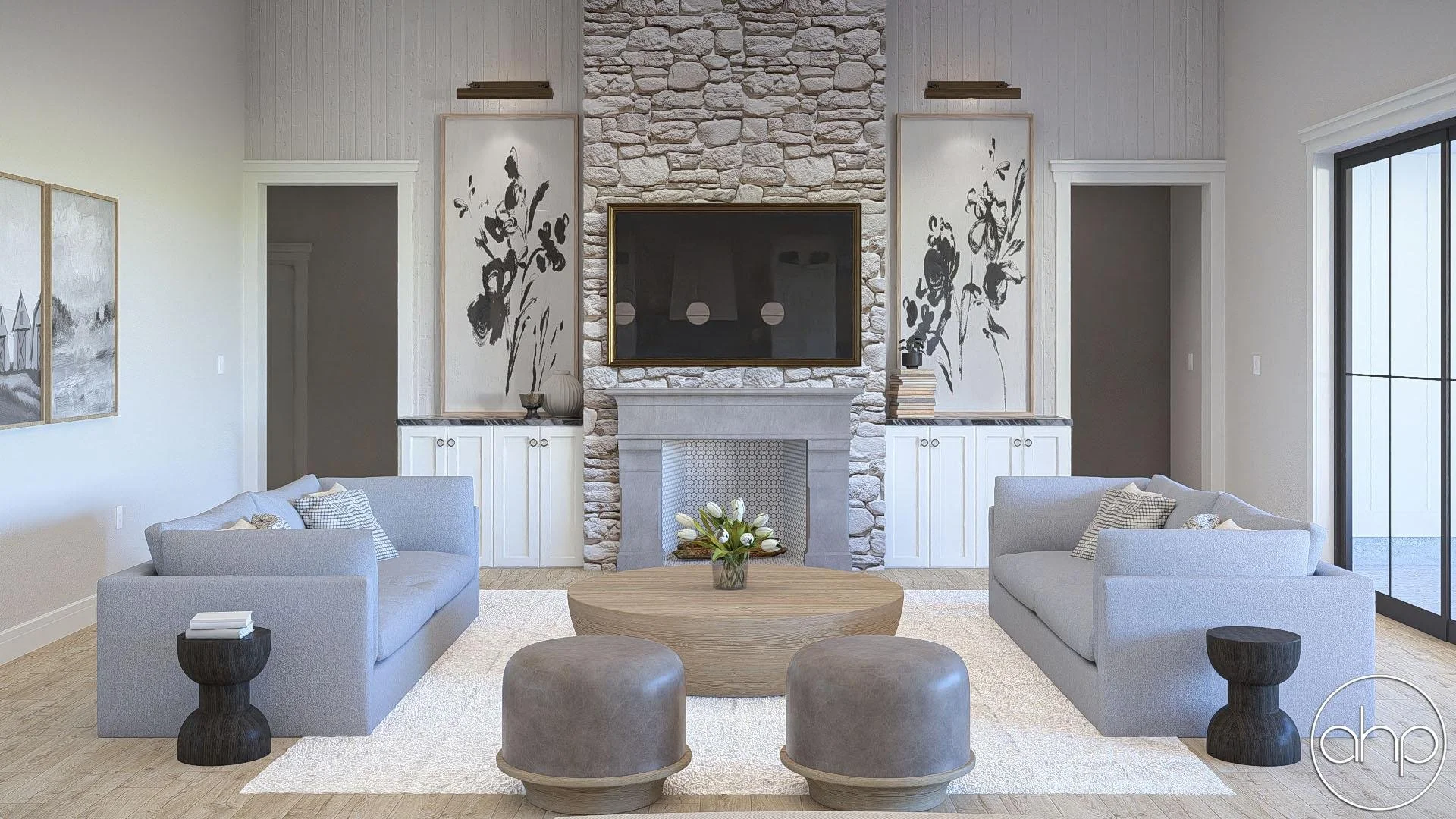 Living room with two gray sofas, a wooden coffee table with a floral arrangement, two dark wooden stools, a stone fireplace, a wall-mounted TV above the fireplace, abstract black and white artwork, and a large sliding glass door.