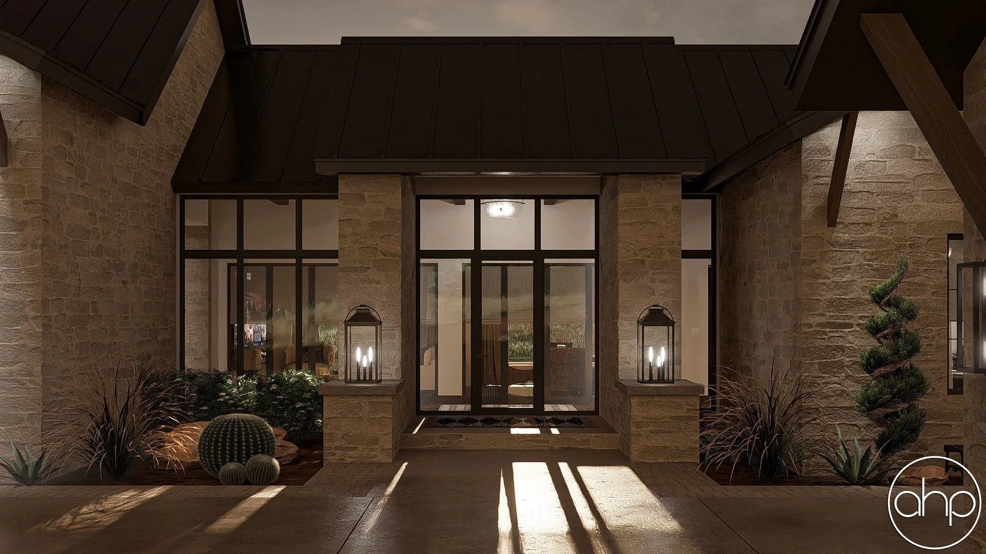 Nighttime view of a house entrance with glass double doors, stone walls, and desert plants, illuminated by lantern-style lights on stone pillars.