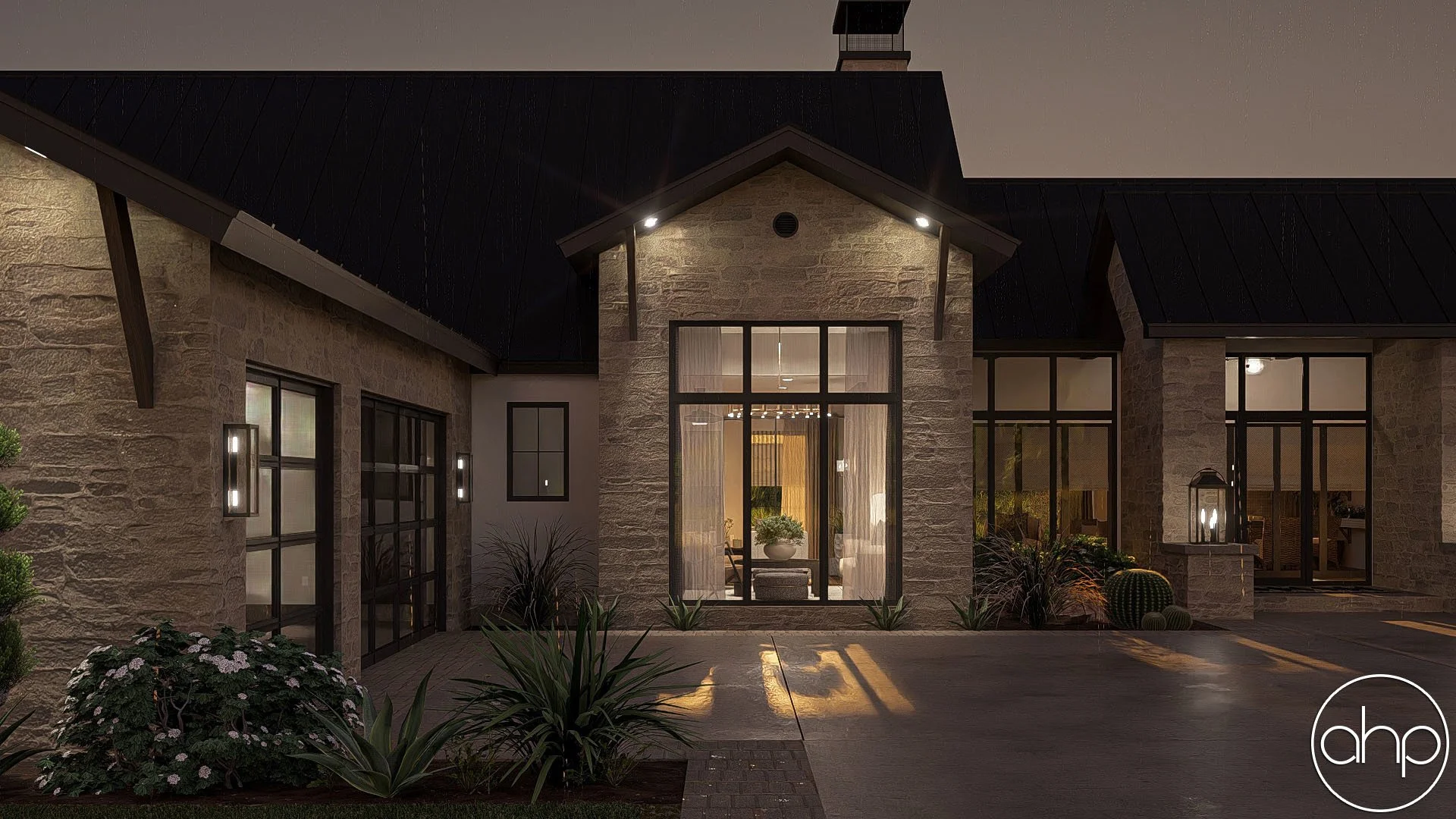 Night view of a modern house with large glass windows and stone exterior, outdoor lighting, and landscaped front yard with plants and cacti.
