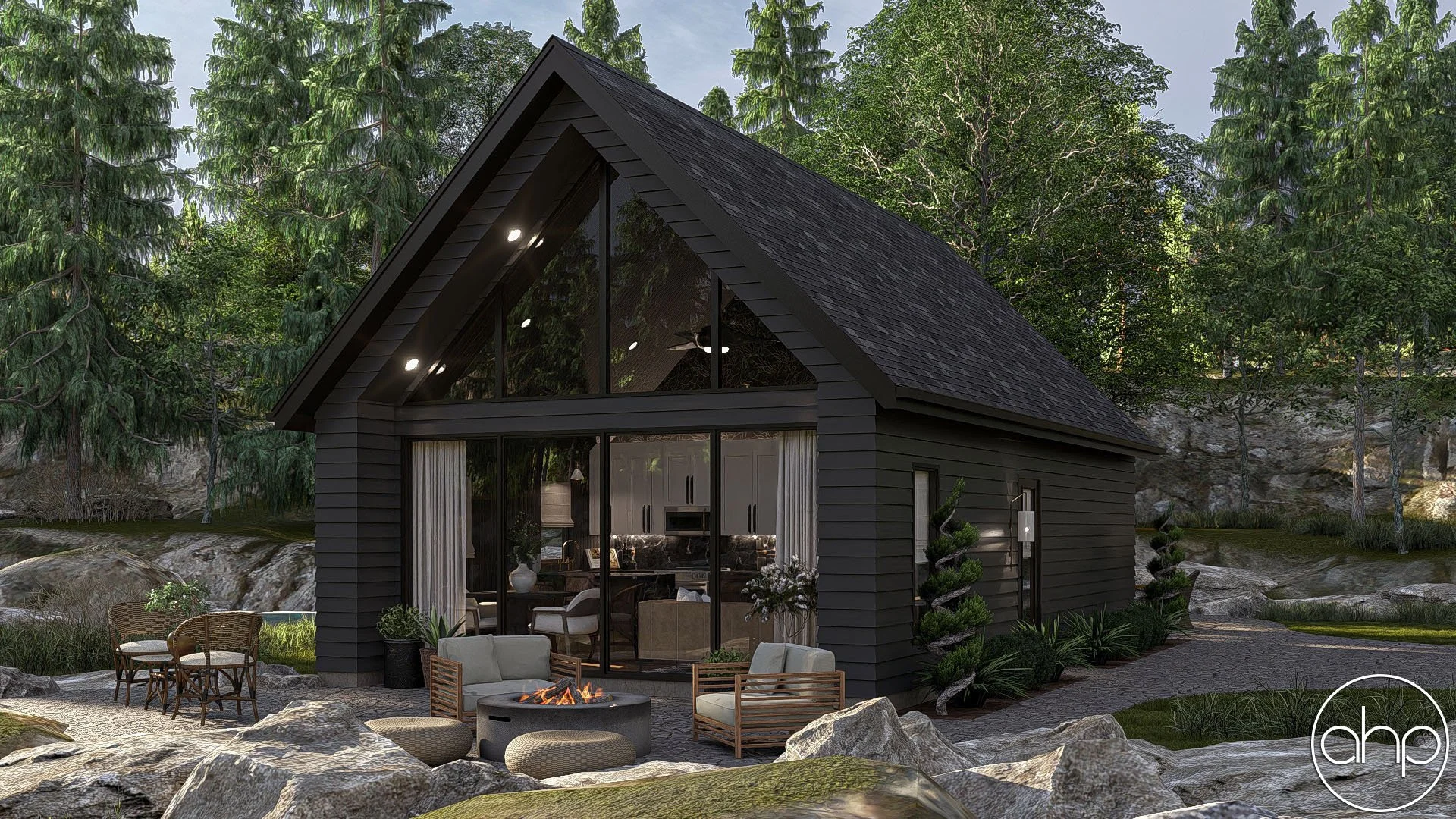 Modern black house with large glass windows in a forest setting, outdoor seating area, fire pit, and landscaped rocks and plants.