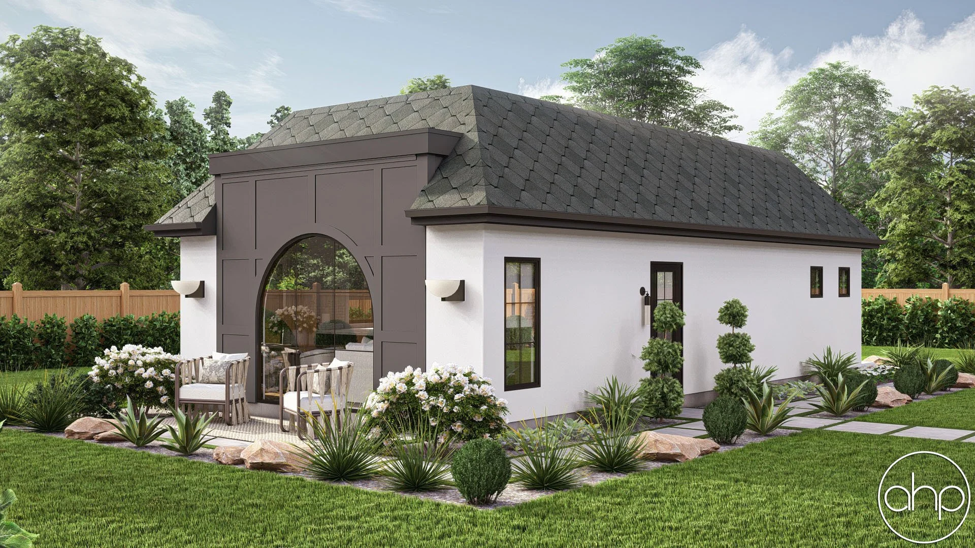 A modern white house with a gray shingled roof, black-framed windows and door, black wall panels, and a small front patio with outdoor seating, surrounded by lush green grass, bushes, and trees.