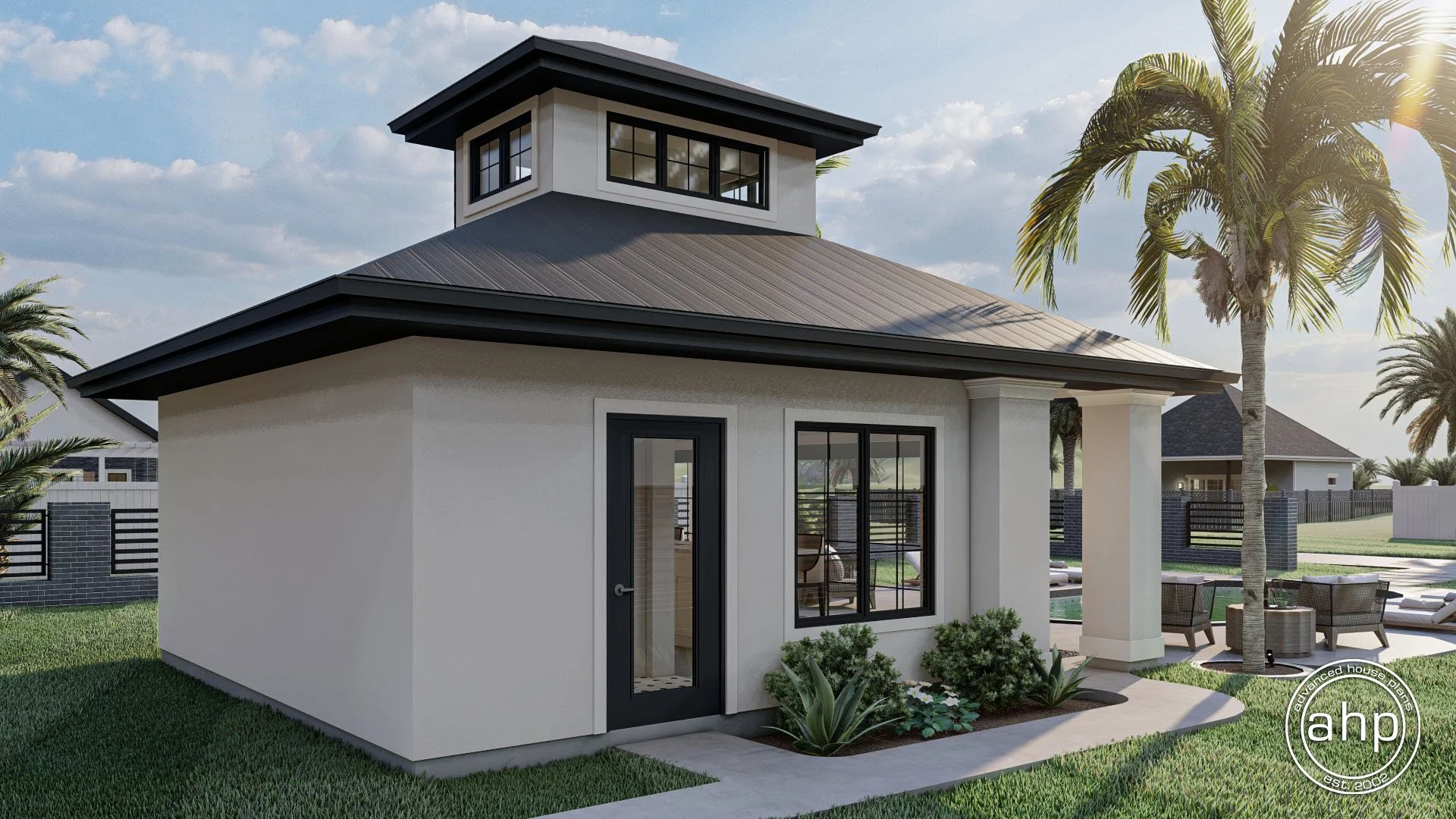 Small modern backyard guest house with white walls, black trim, and a cupola roof. It is surrounded by green grass, palm trees, and outdoor seating areas.