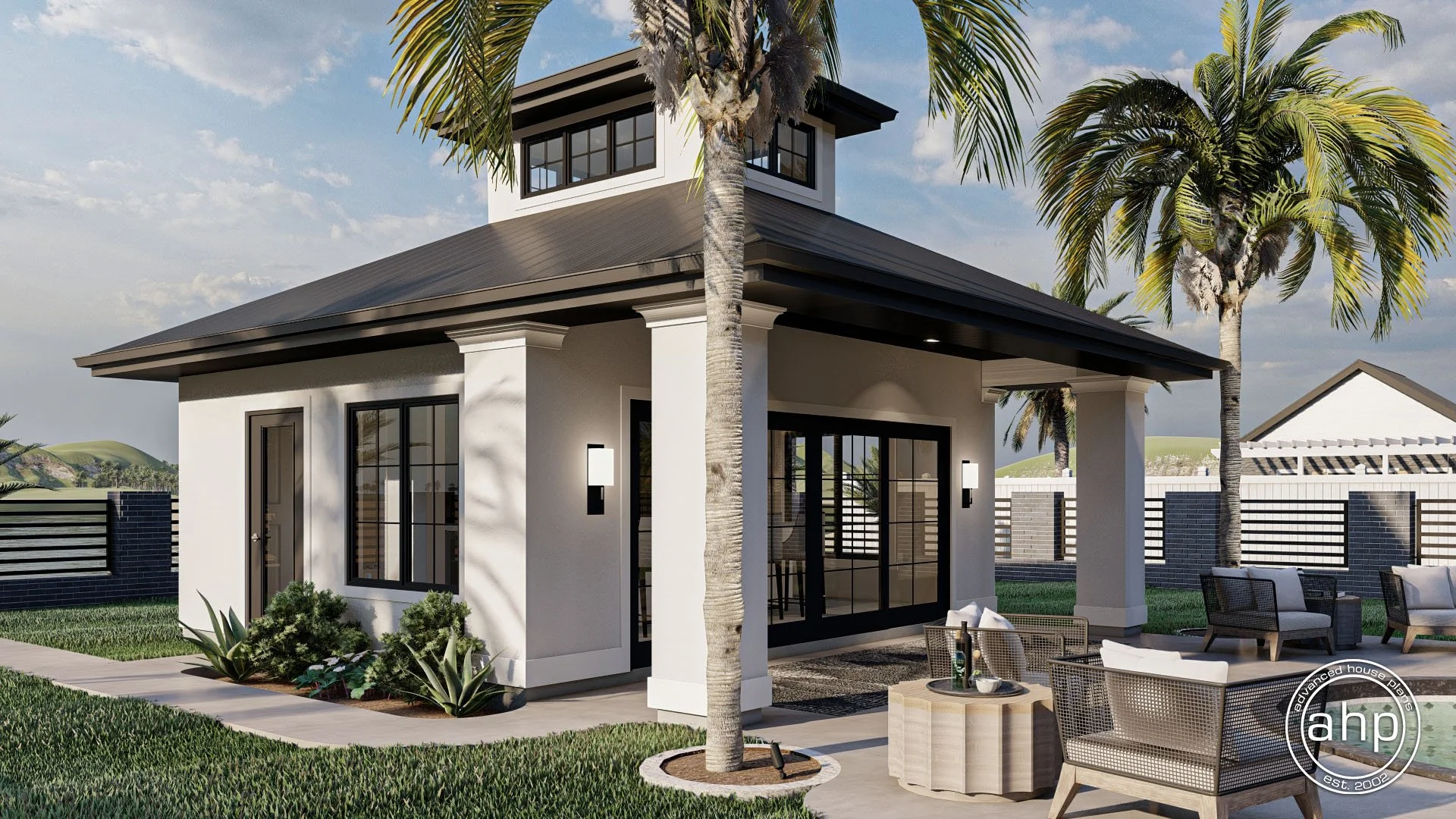 A modern two-story house with white walls, black window frames, and a dark roof, surrounded by palm trees and a manicured lawn, with outdoor seating and a fence in the background.