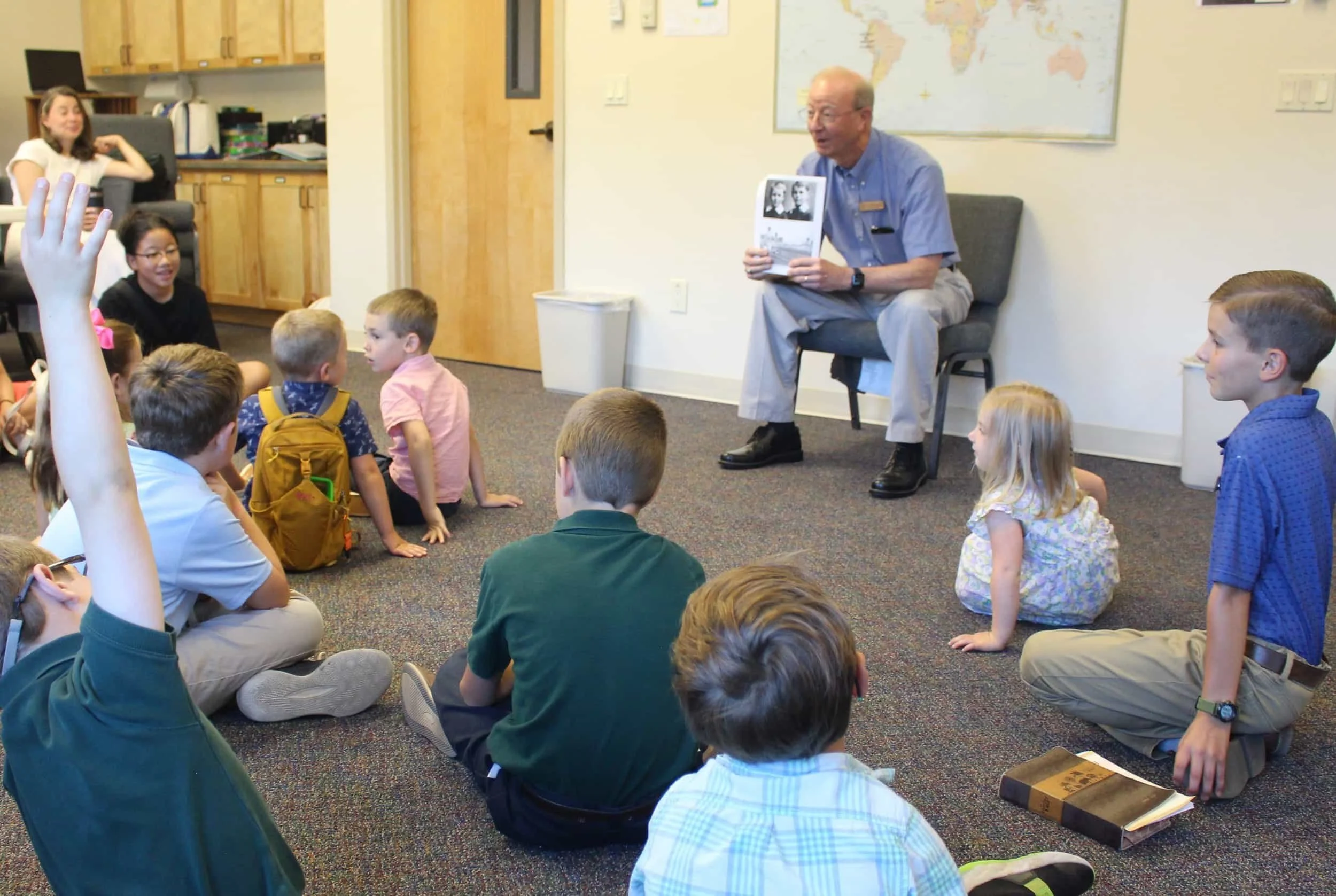 An older man at Forestgate Presbyterian Church reads to children in a classroom.