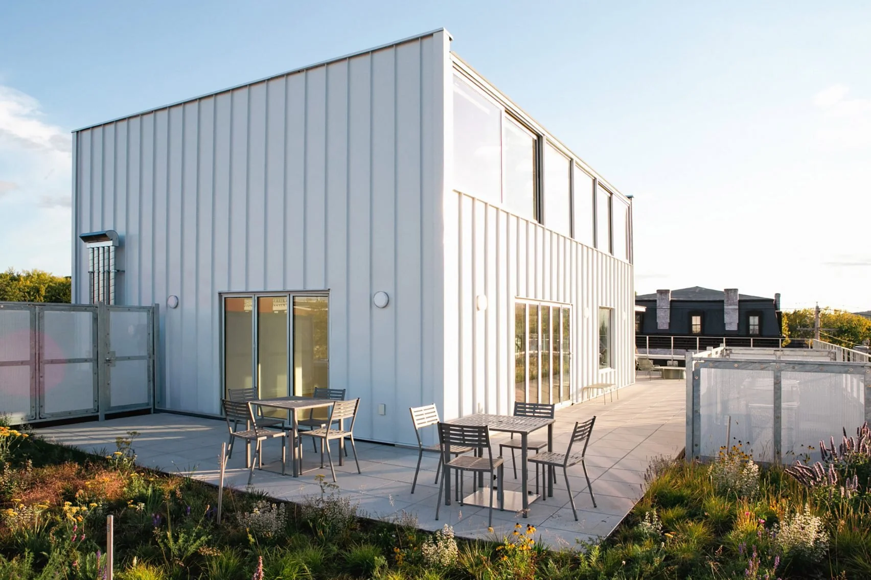 A large wrap around stone patio with natural garden on the rooftop of The Spark of Hudson
