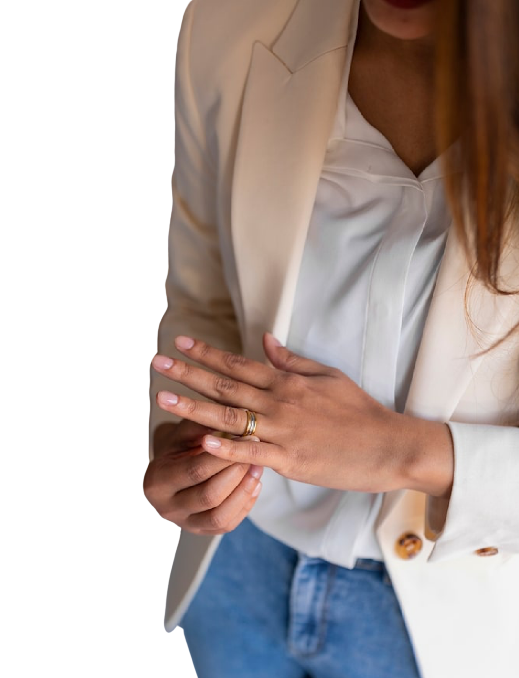 A woman wearing a white blazer and white blouse, with a ring on her finger, is holding her wrist with her other hand.