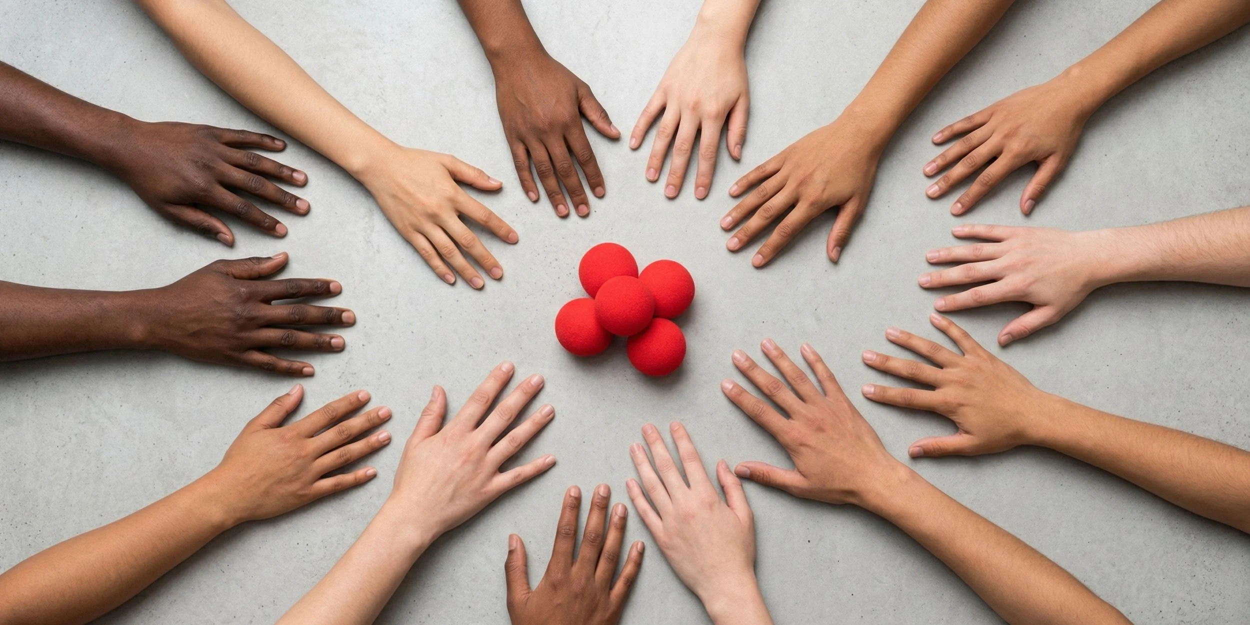 Multiple hands of diverse skin tones reaching towards a cluster of six red clown noses on a light gray surface.