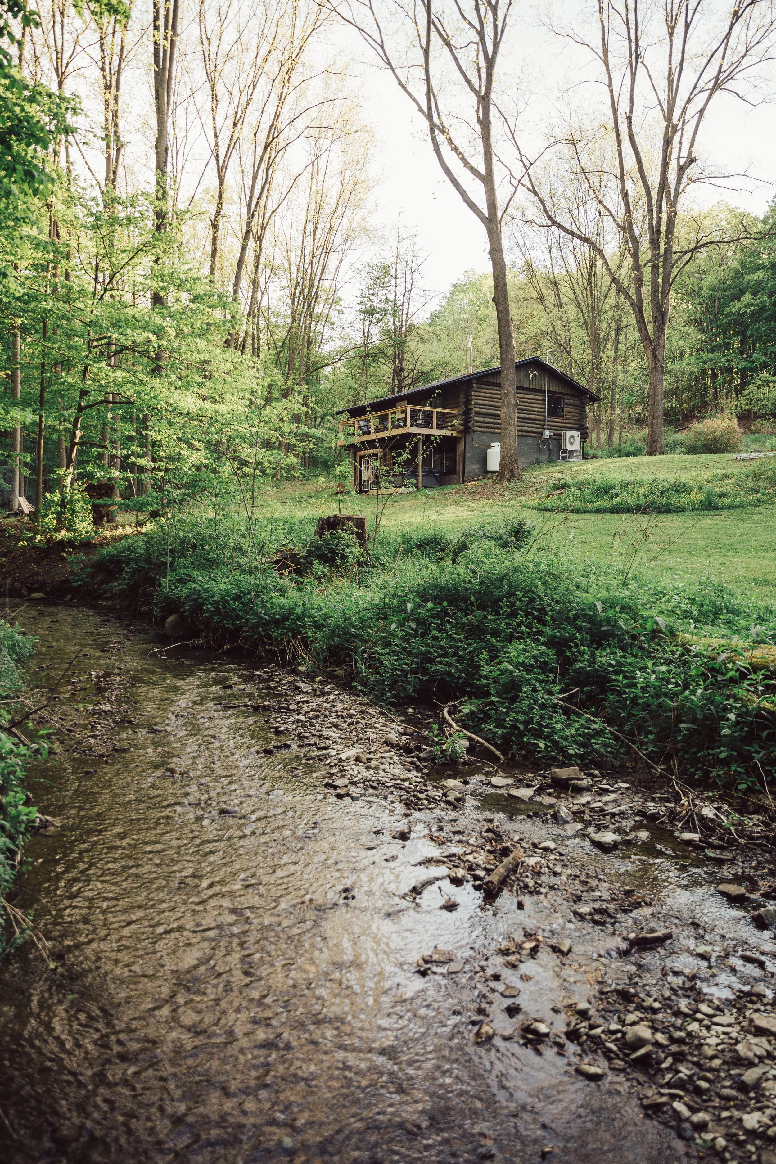 LOG CABIN CHARM ~ 
Situated on quiet winding road with four private acres, a stream, and a beautiful view of nature!