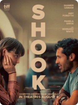 A promotional poster for the film 'Shook' featuring a woman and a man sitting face-to-face, seemingly engaged in a serious conversation, with the title 'SHOOK' in large letters.