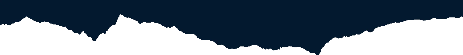 Silhouette of mountain range against dark night sky.