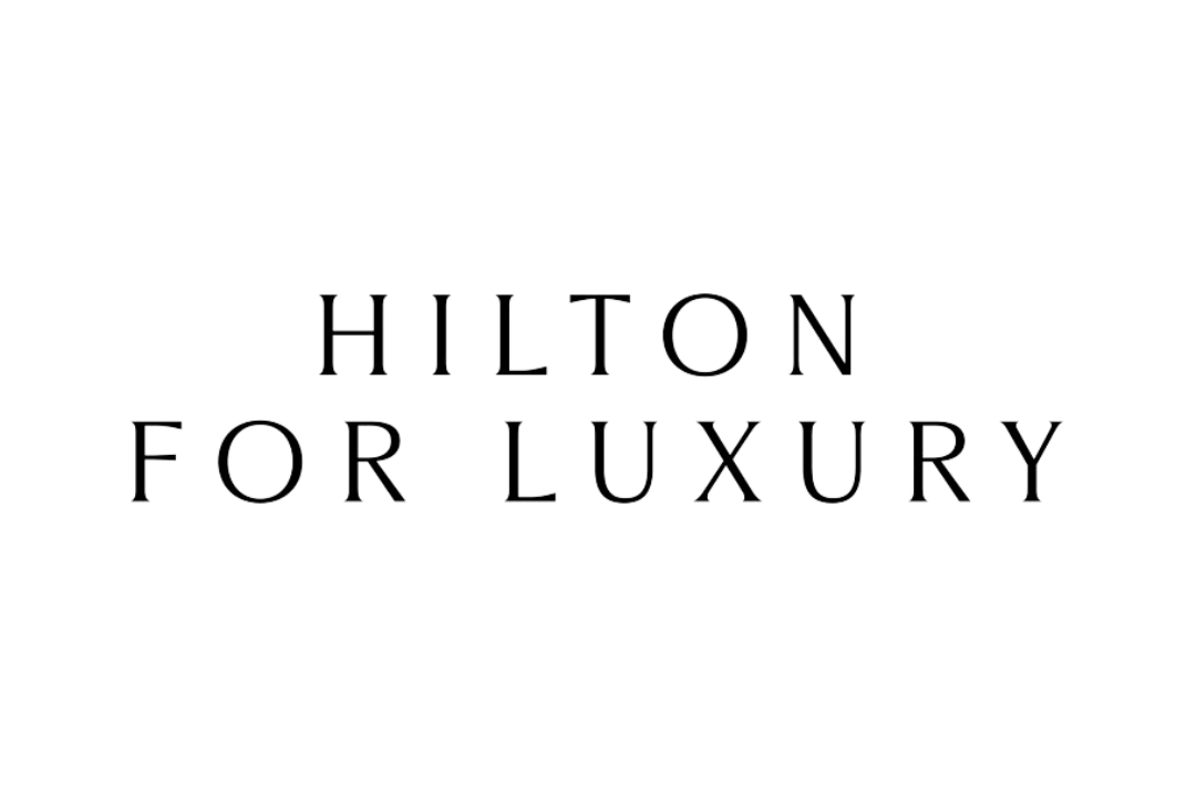 Hotel logo with the text "Hilton for Luxury" in metallic silver letters on a black background.