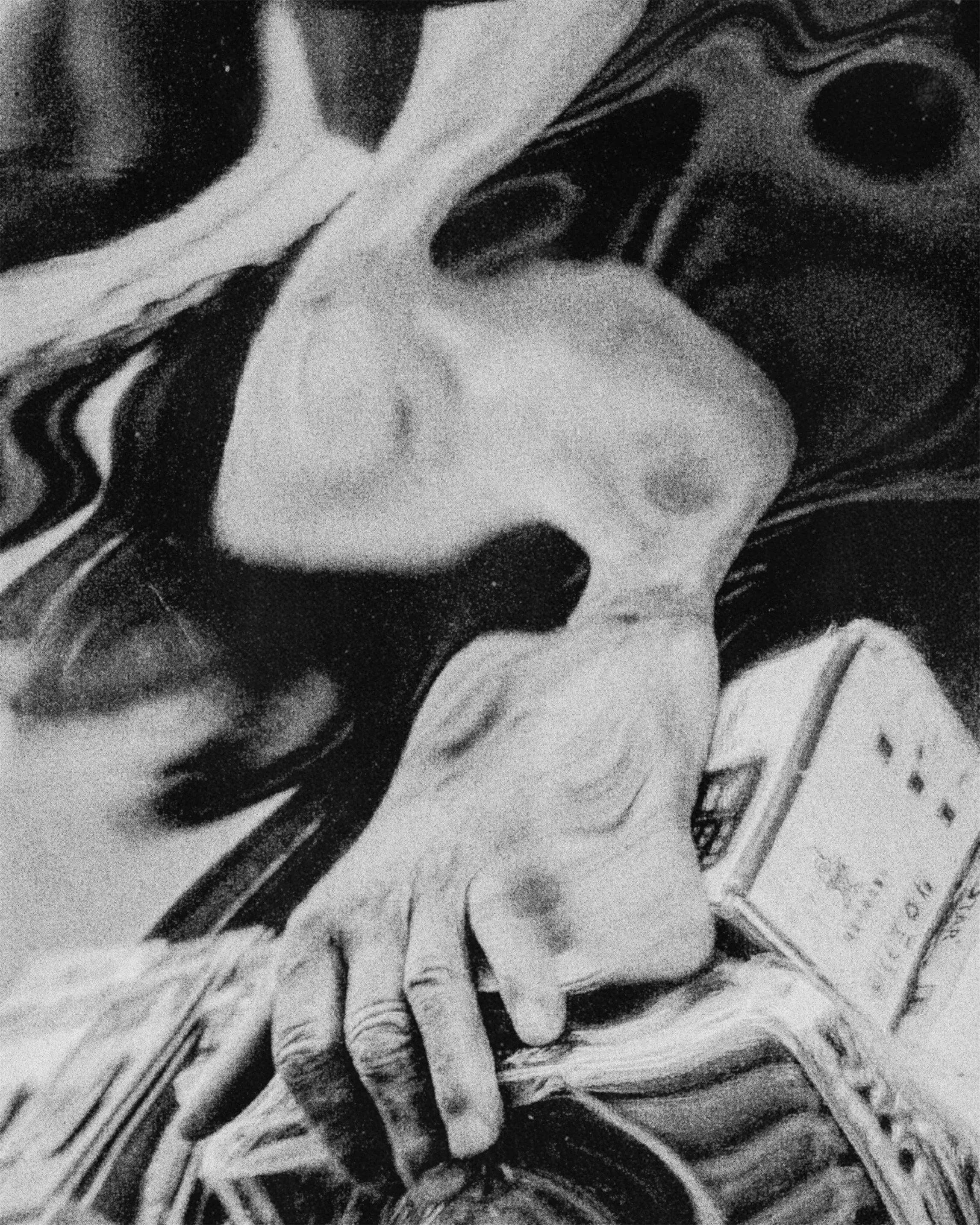 Close-up of a person holding a surgical mask in front of their mouth.