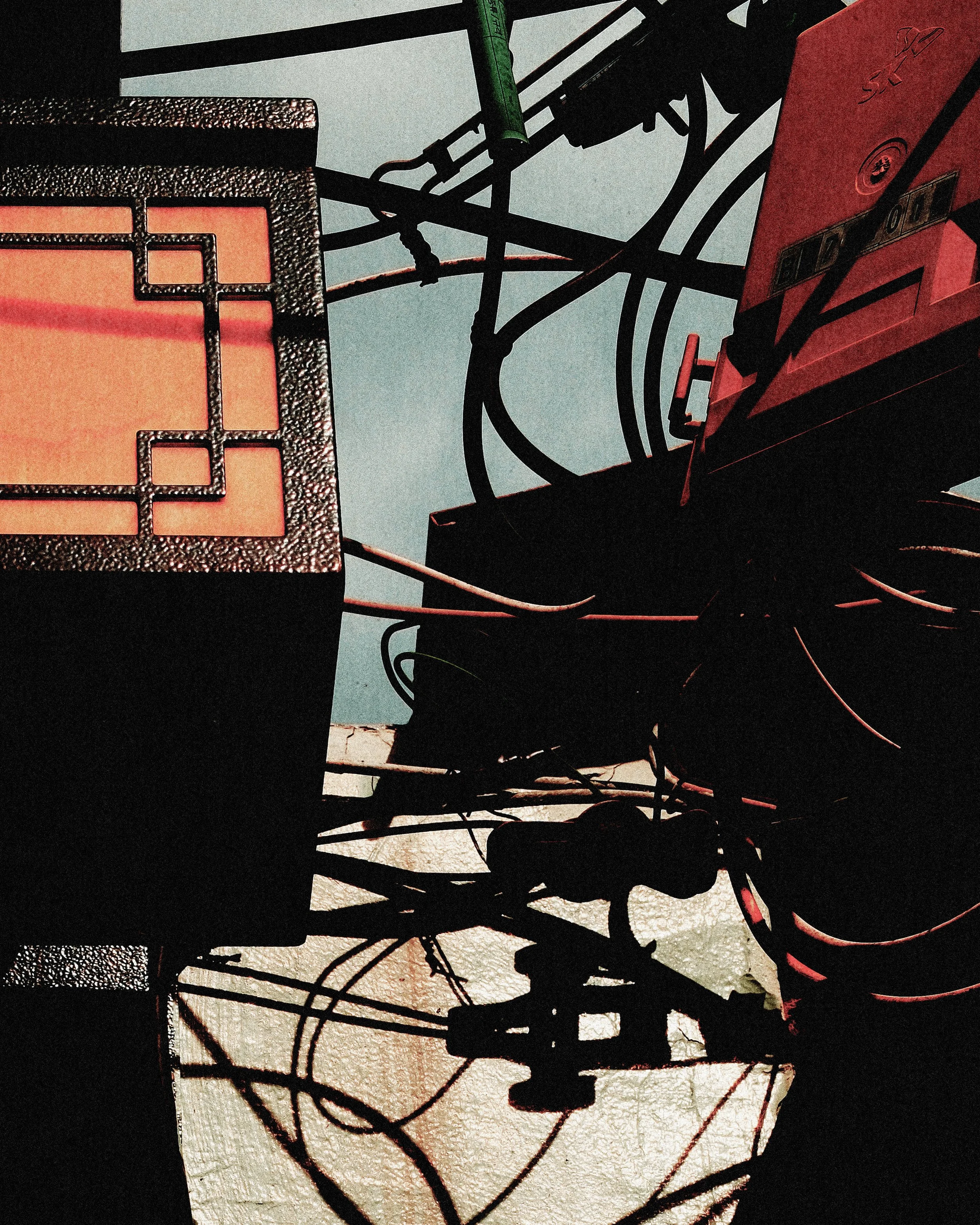 Silhouette of tangled wires and electronic equipment against a background of graffiti art on a wall.