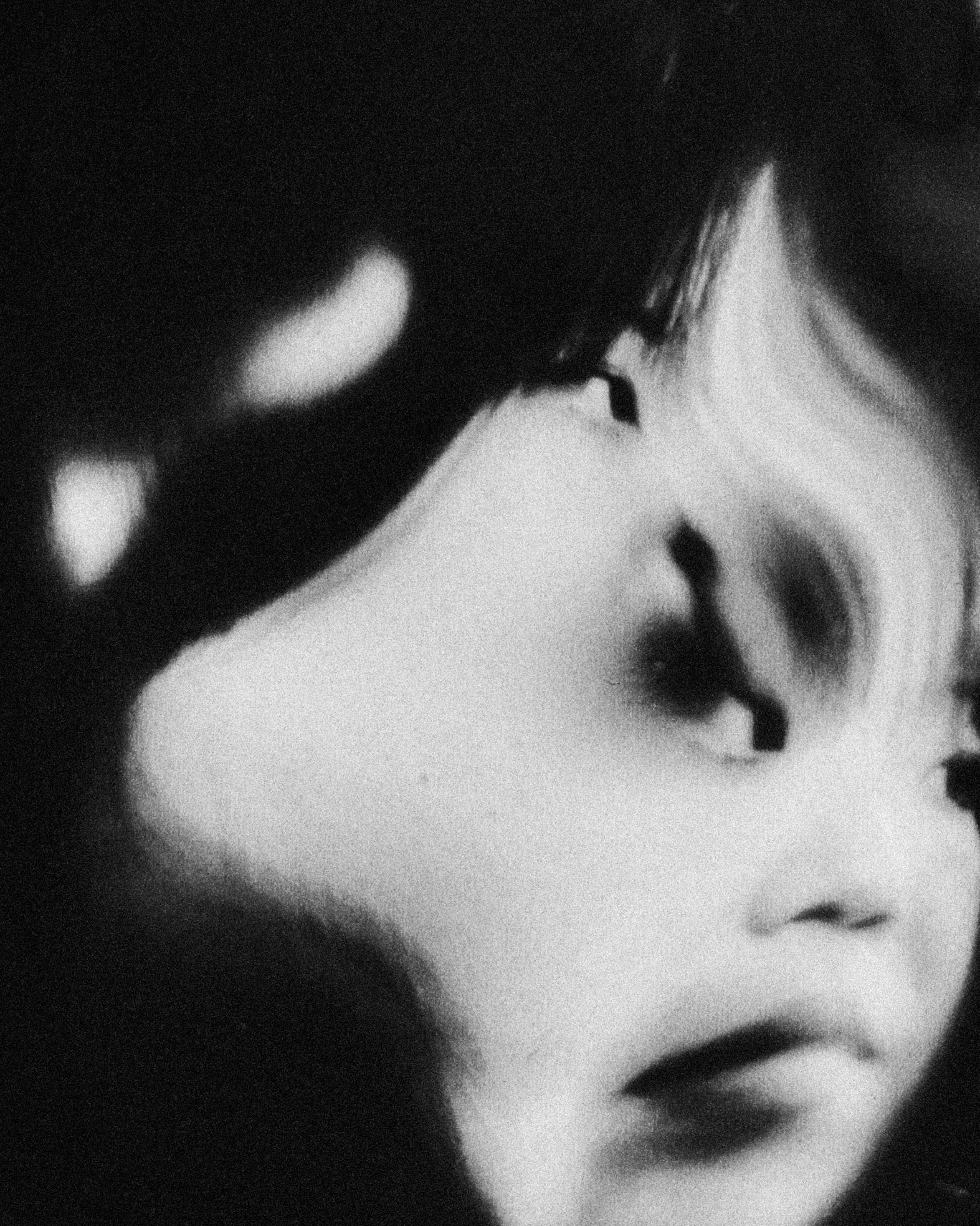 Close-up black-and-white photo of a woman's face, focusing on her eye, nose, and lips.