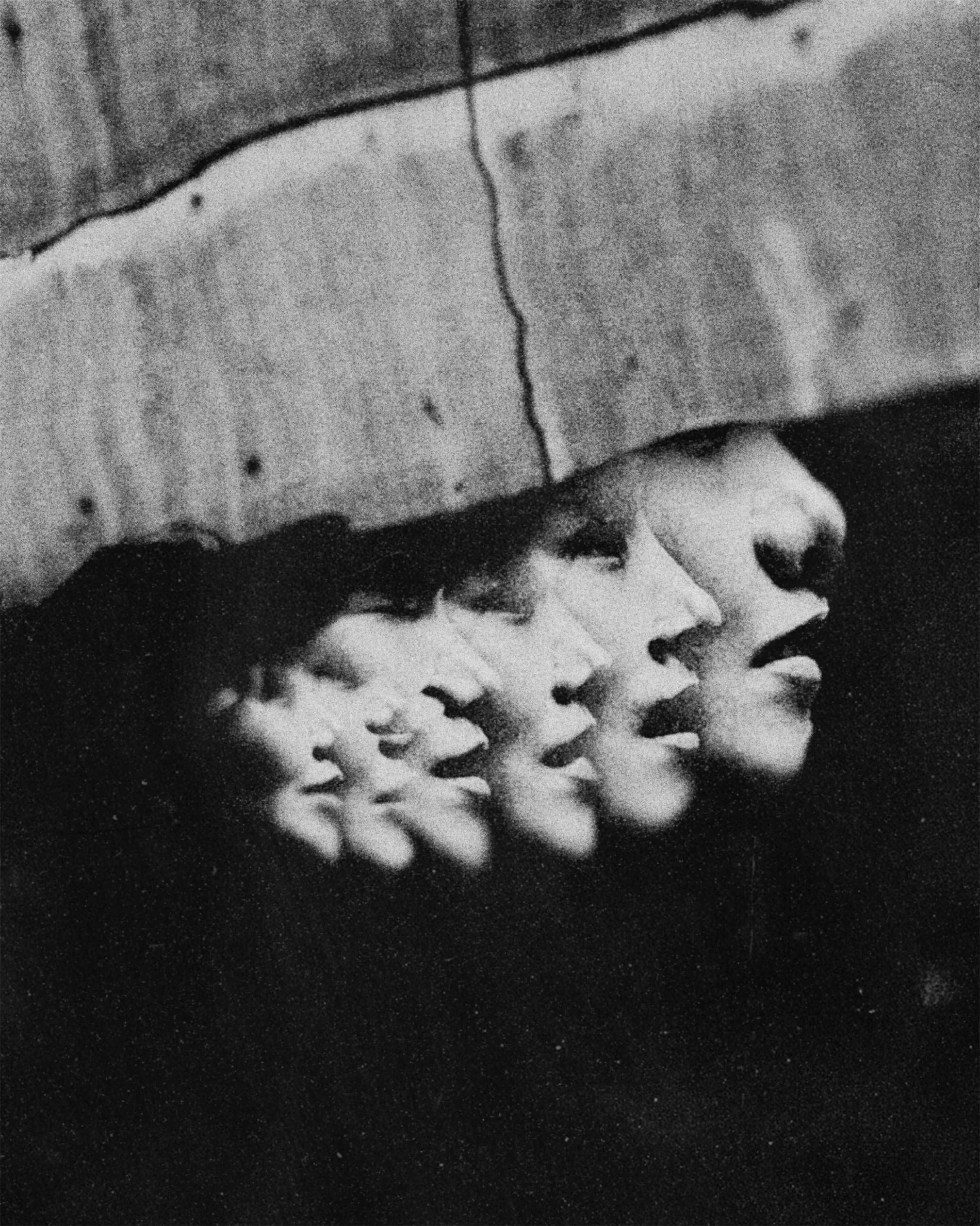 Black and white photograph of a partially eaten ice cream sandwich, showing the ice cream and cookie layers, with some ice cream spilled on a dark surface.