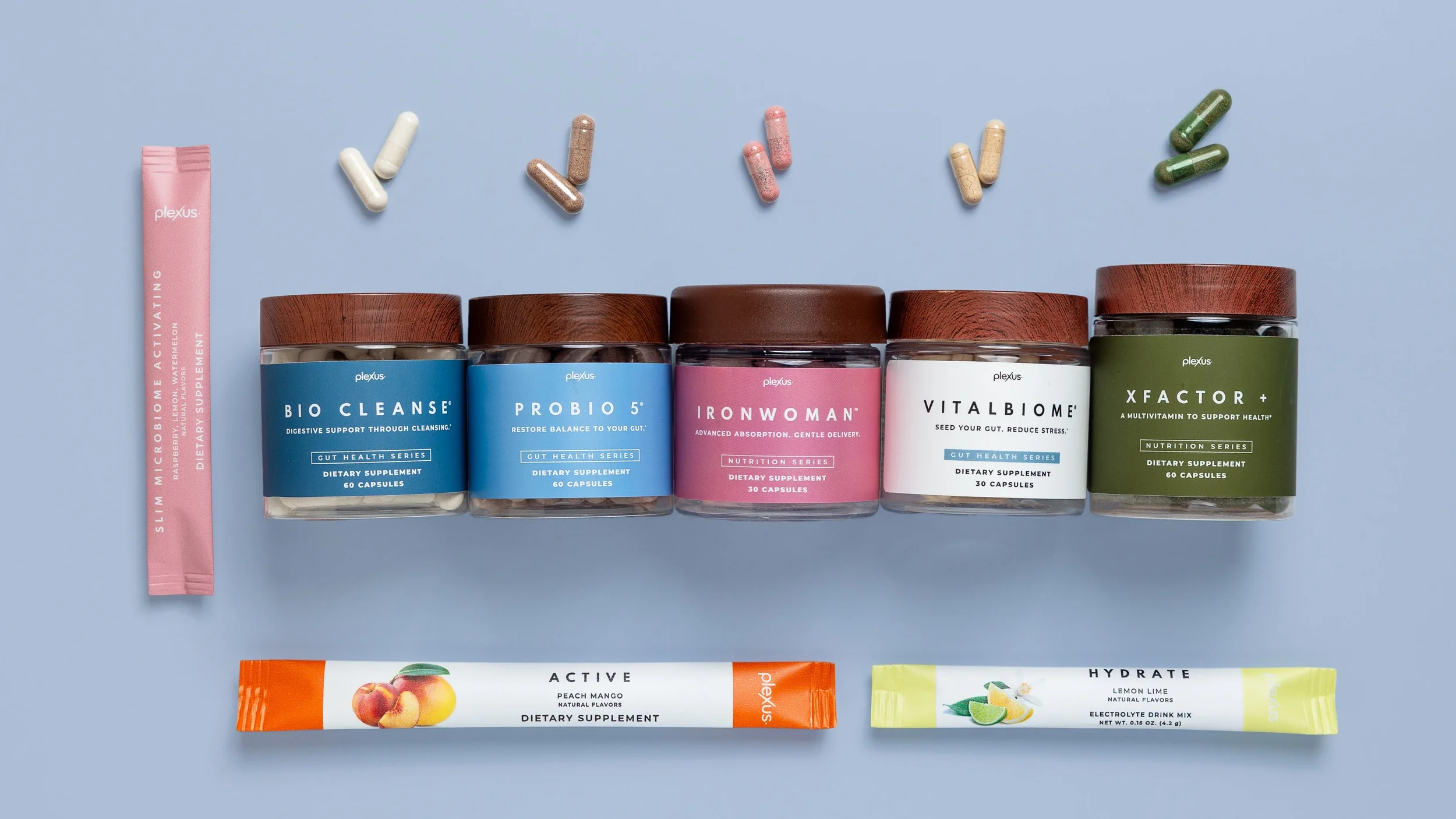 Collection of dietary supplement containers and packets on a light blue background, including pills and powder sticks.