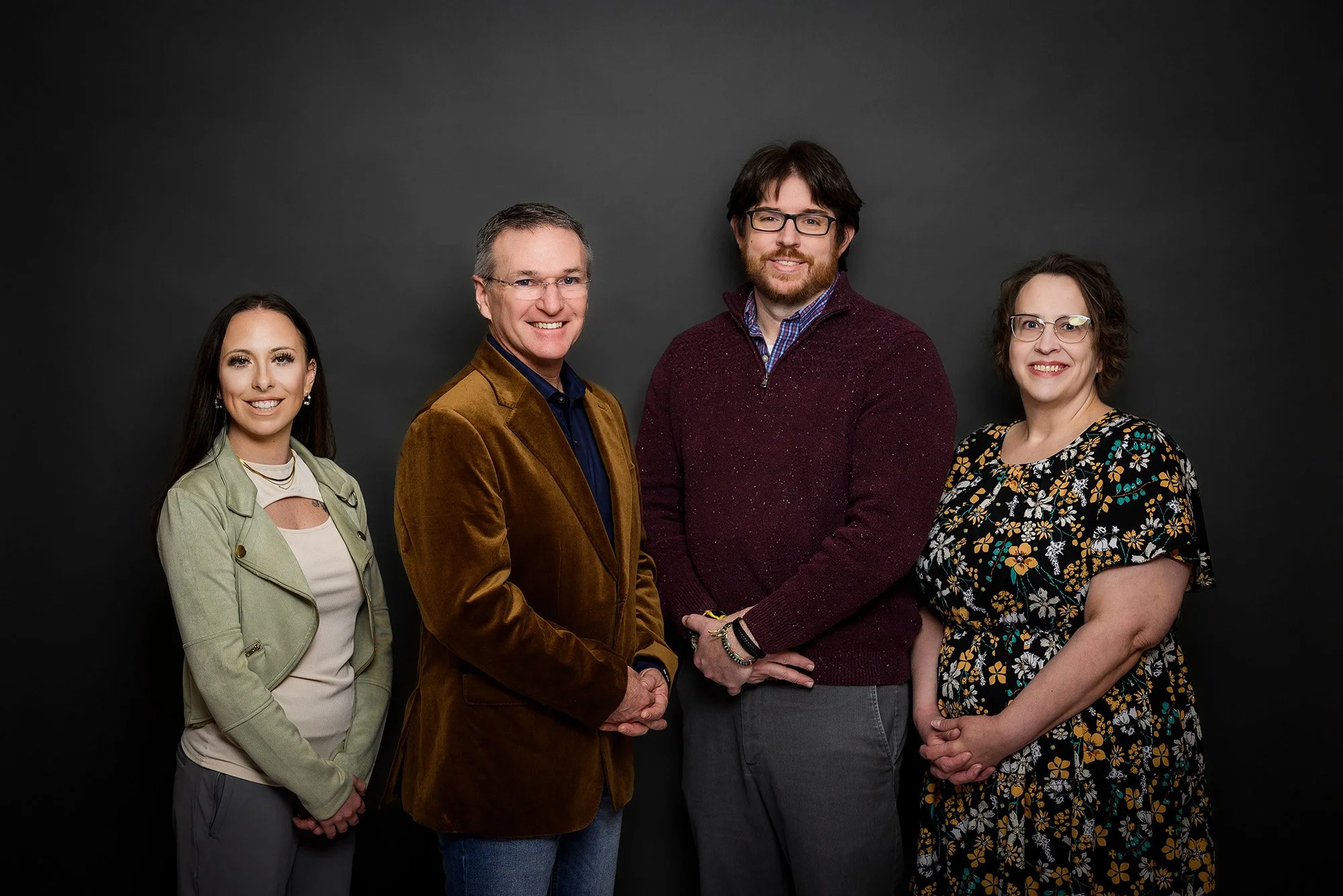 An image of Counseling Associates clinical staff with a dark background. Pictured from left to right are four people: Summer Miller, Michael Maher, Garret Anthony, and Dawn Combites.