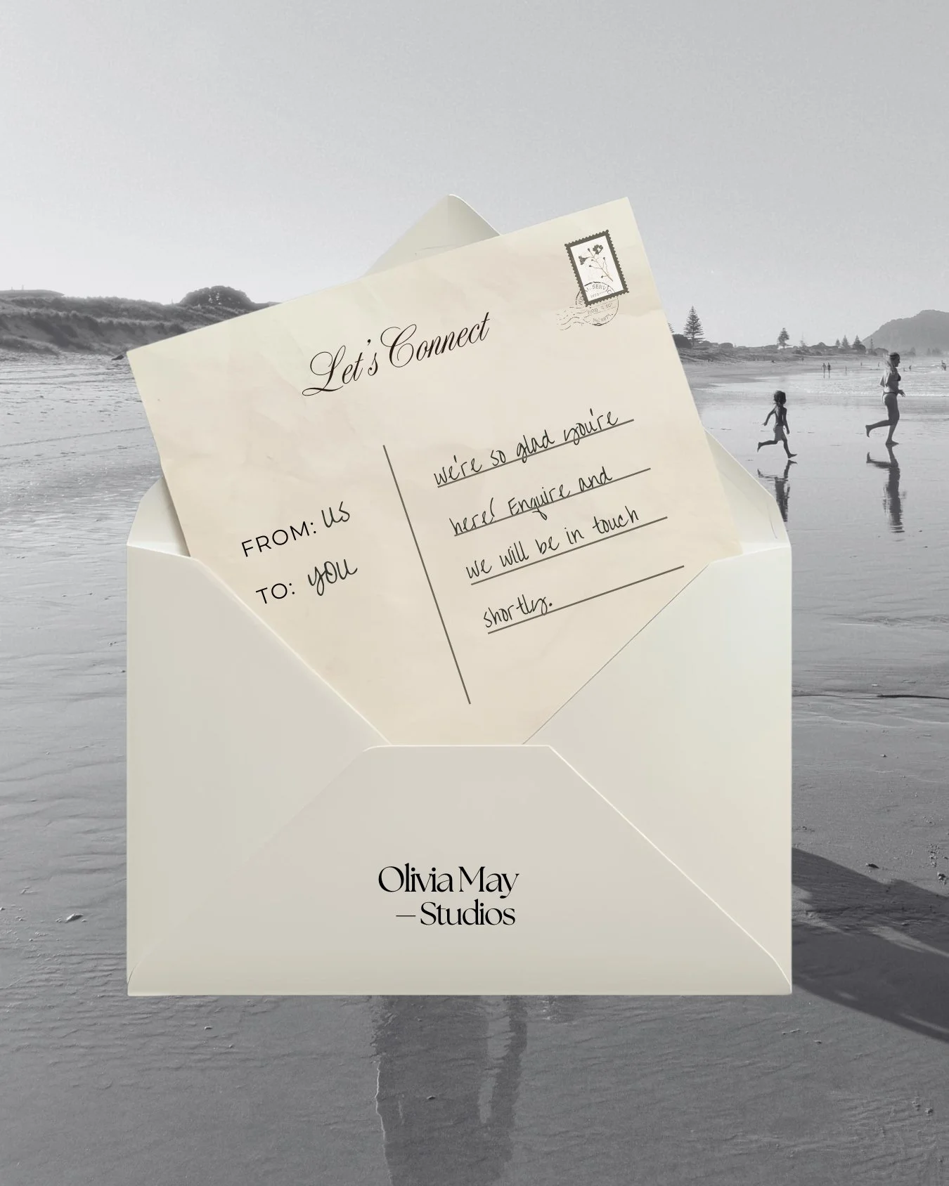 A handwritten note on a piece of paper inside an envelope resting on the sand at the beach. The note says: "Let's Connect. We're so glad you're here! Enquire and we will be in touch shortly." In the background, there are people walking and playing on the beach with shoreline, hills, and trees visible.