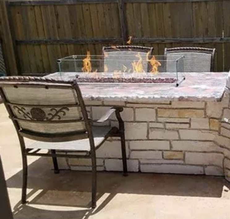 Outdoor patio table with a built-in fire pit, surrounded by chairs.