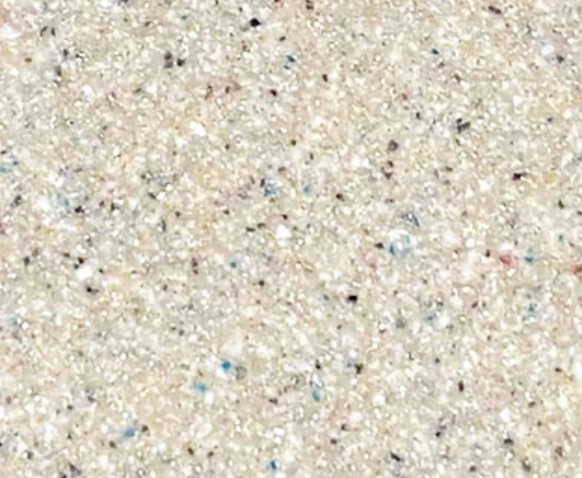 Close-up of a beige, speckled sandy beach surface.