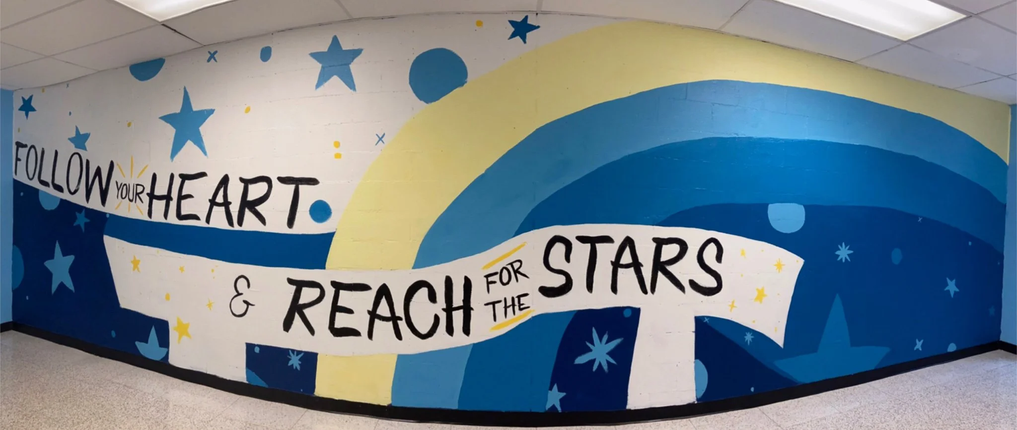 Colorful mural with stars, rainbows, and the inspirational quote 'Follow your heart & reach for the stars'.