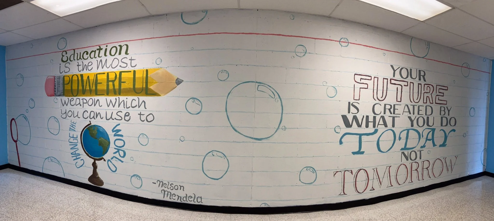 Colorful mural with a quote about education and the future, featuring a pencil illustration and a globe, with a background of bubbles and a line pattern.