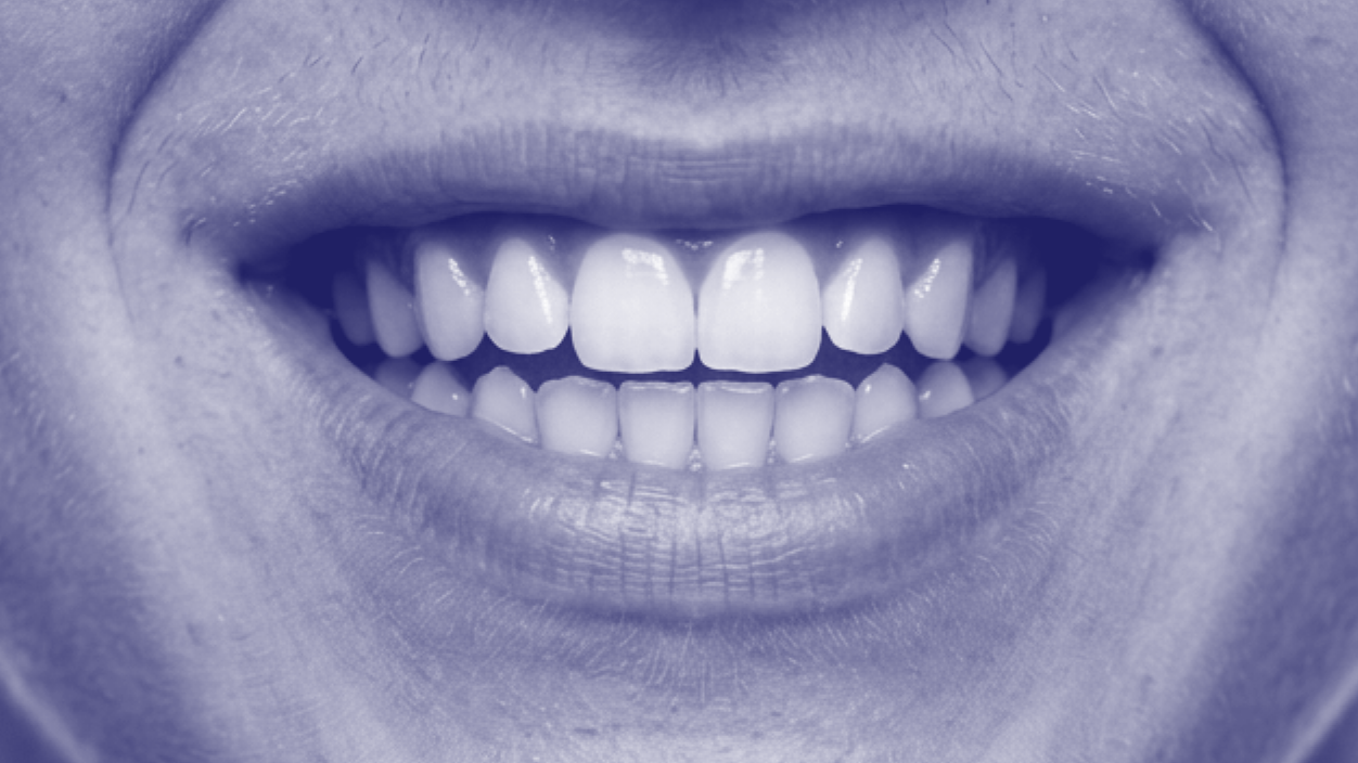 Close-up of a smiling person's mouth showing teeth and lips.
