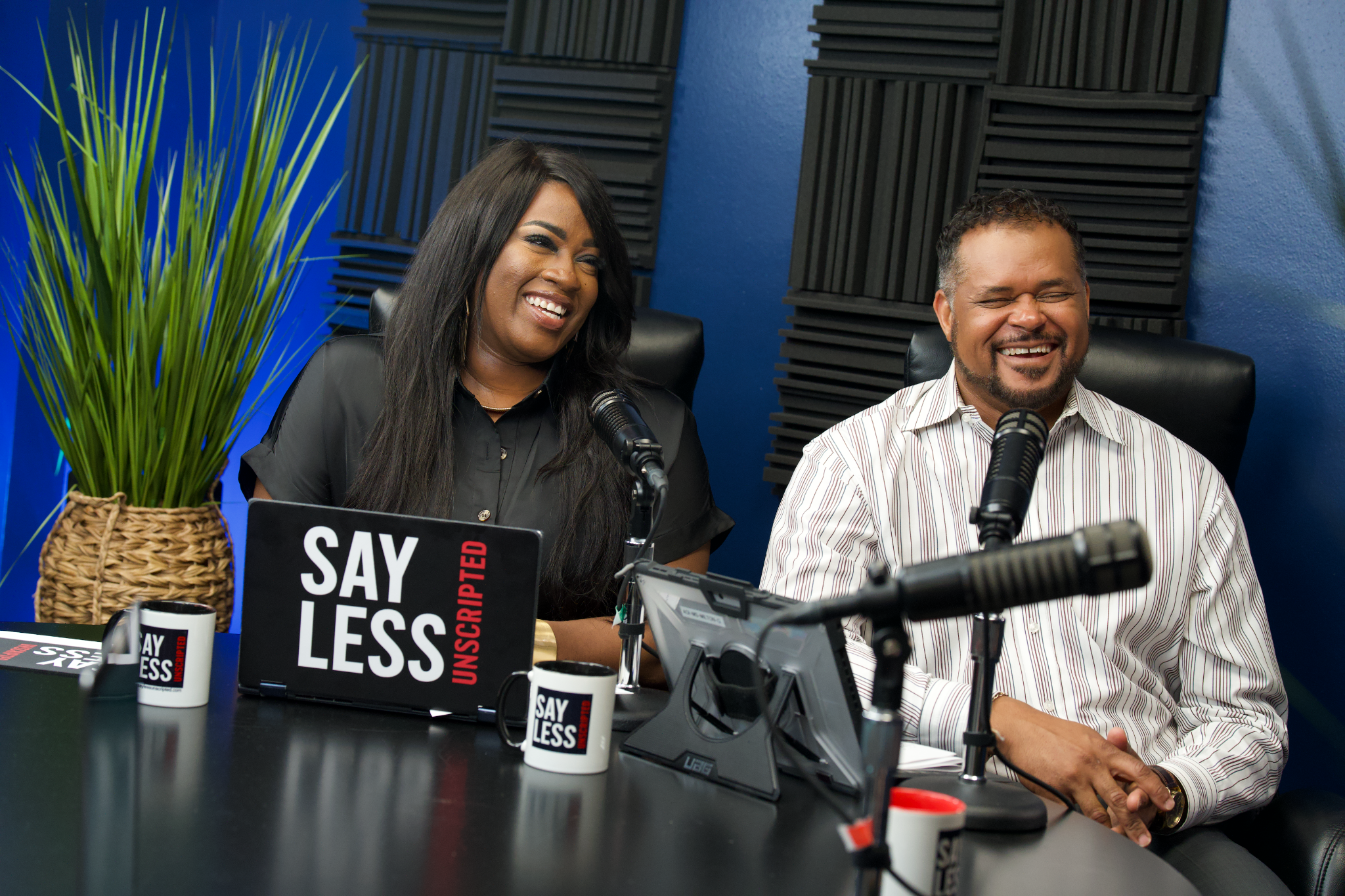 Say Less Unscripted co-hosts Milton Quinn and Jacquelyn Clayborn speaking into microphones during a podcast conversation