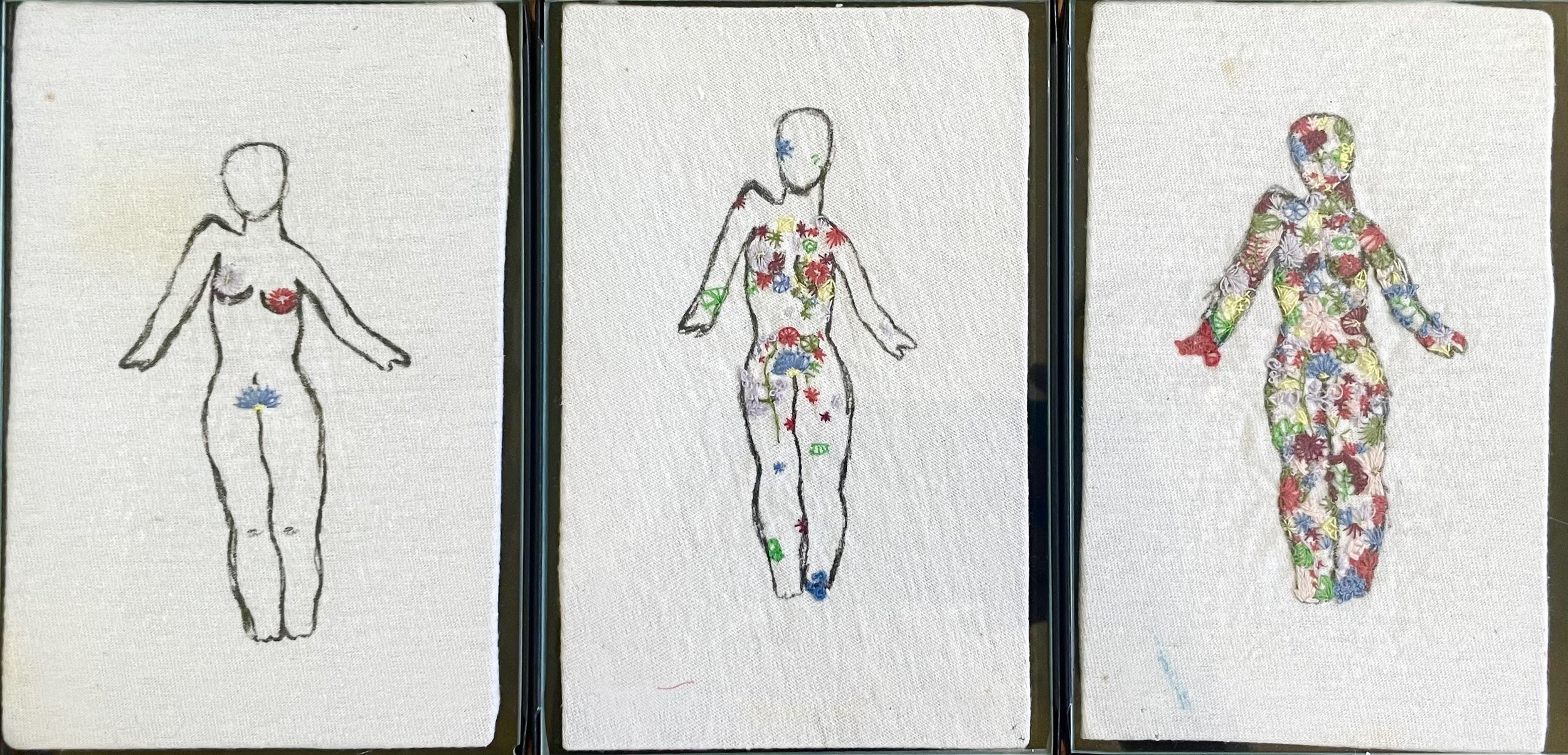 Three embroidered fabric sketches of human figures in different stages of dress. The first is a simple outline with minimal color, the second has more detailed outlines with multicolored floral embroidery, and the third is fully embroidered with a colorful floral pattern covering the entire body and head.