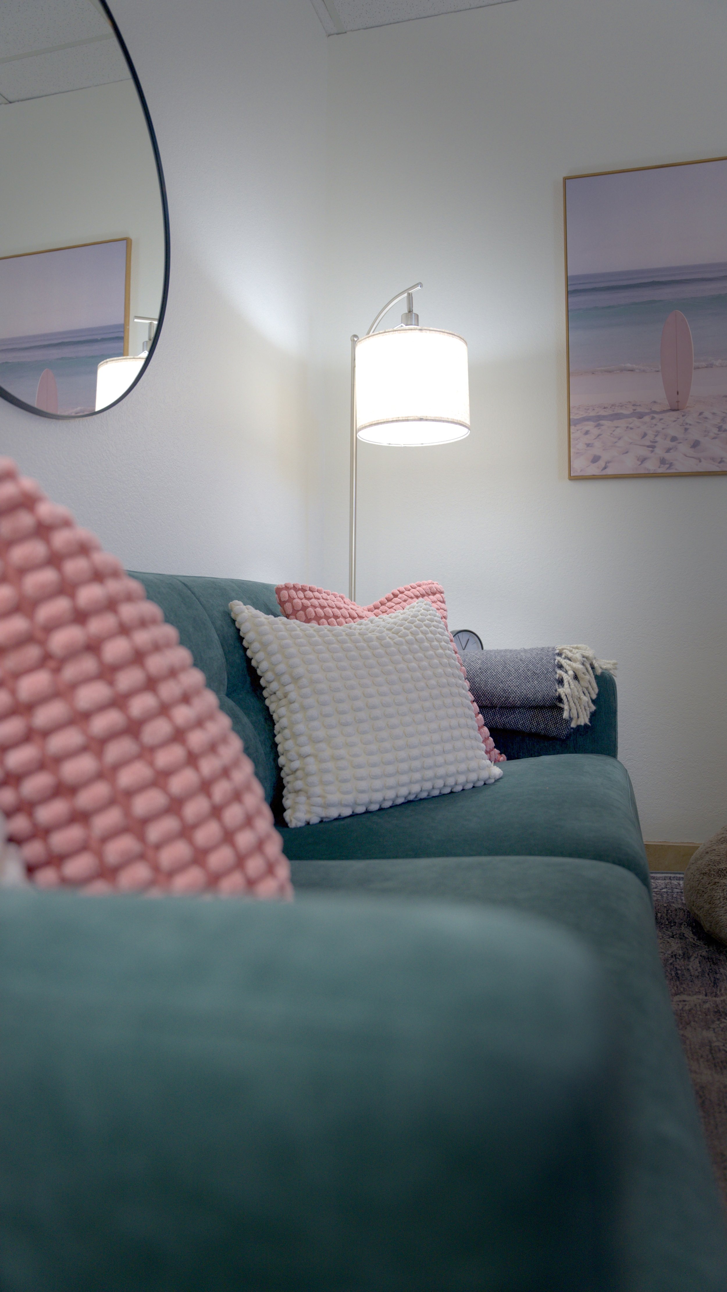 Cozy therapy room with a teal couch and pillows