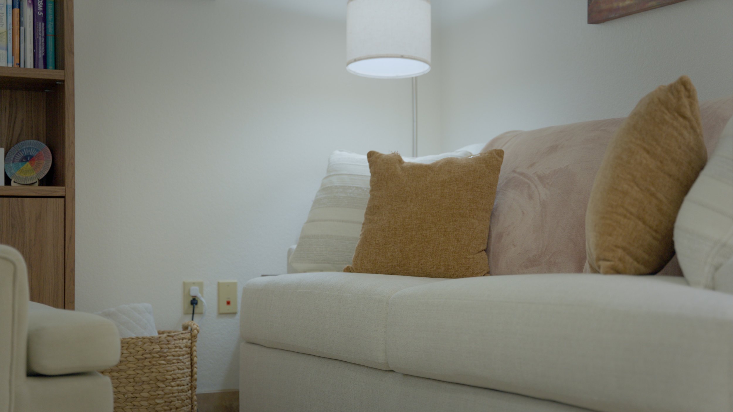 Cozy white sofa with a woven basket and soft pillows