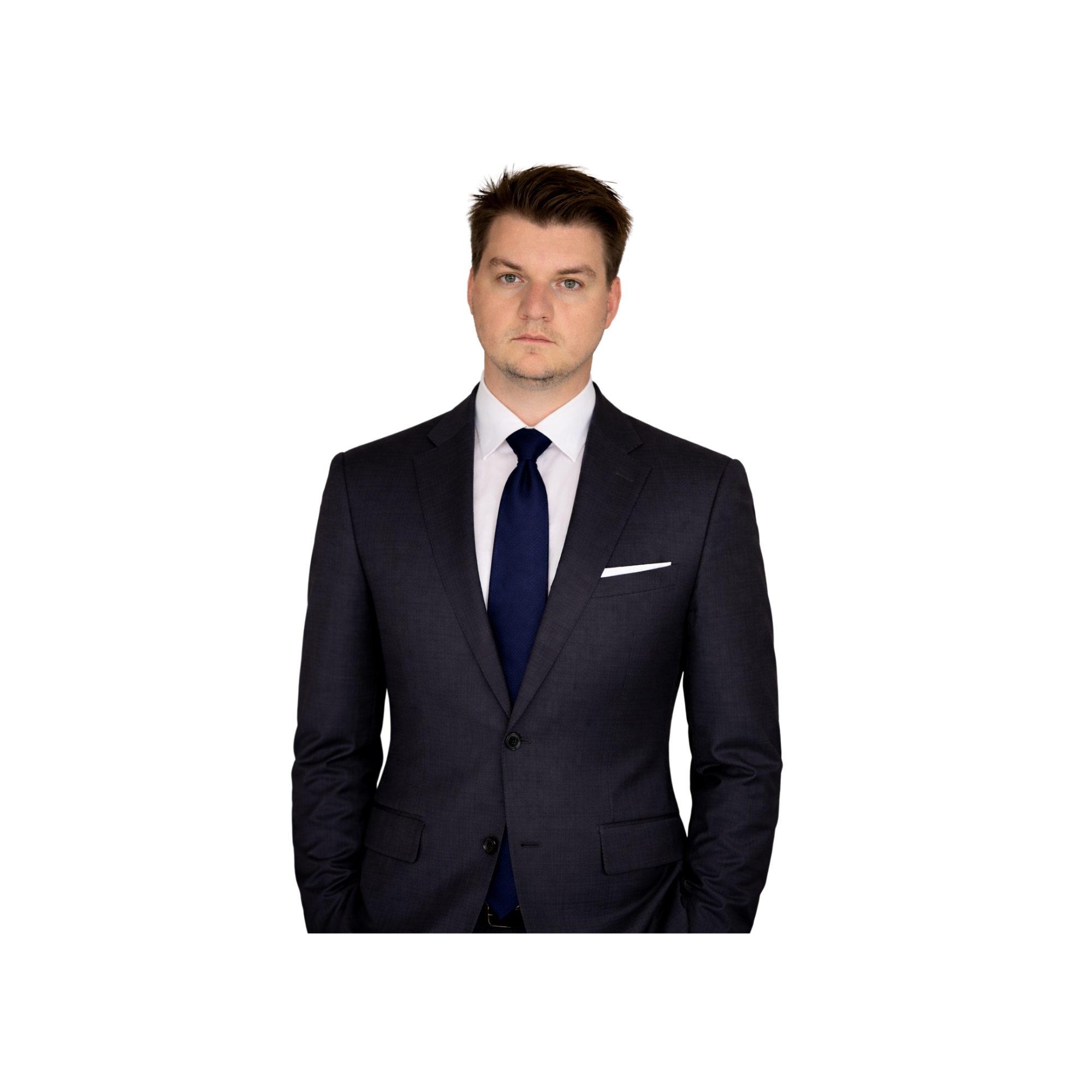 A man in a dark suit, white shirt, and dark tie, standing with arms crossed in front of a black background.