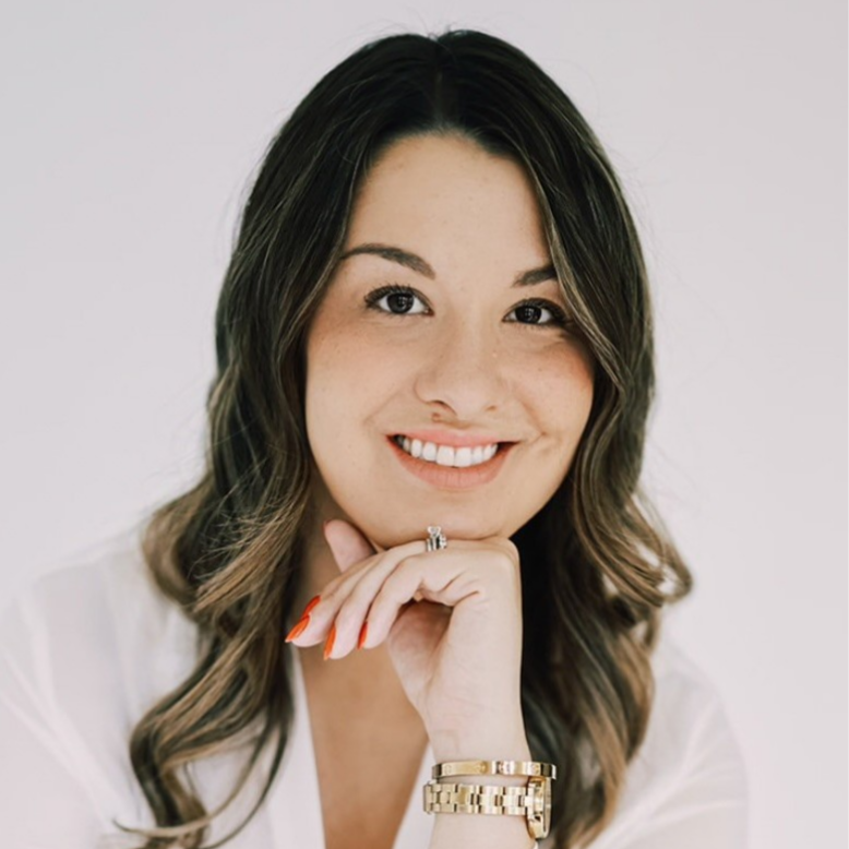 Stefanie Dross smiling indoors with white background.