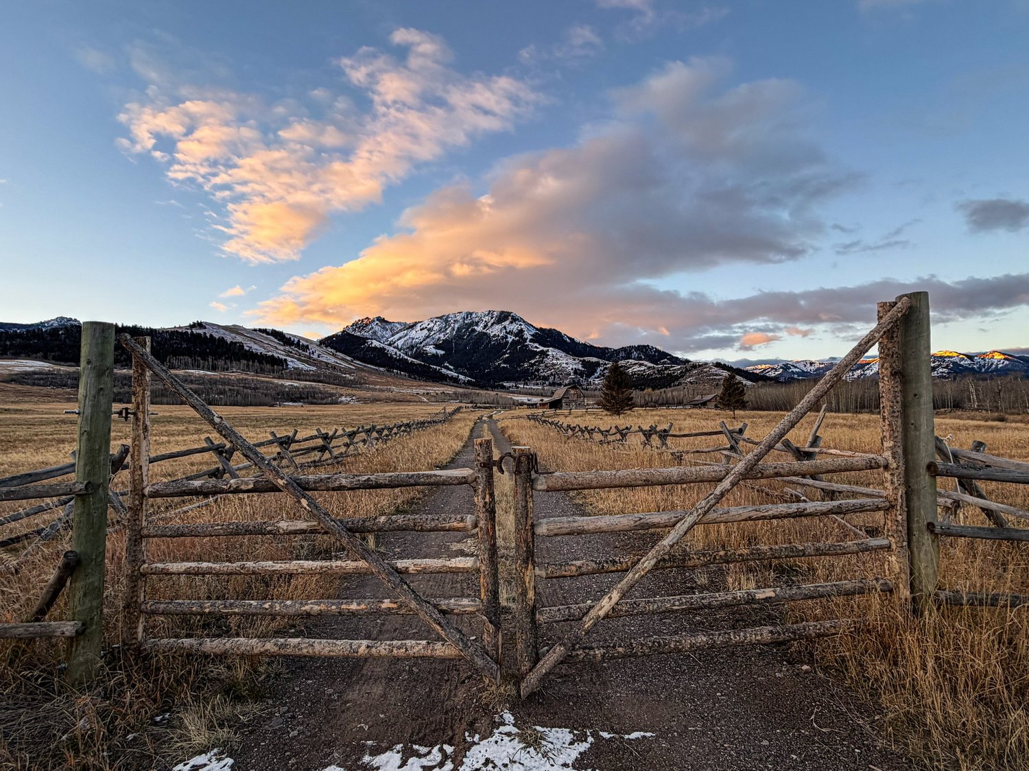 Ranch gate at sunset in Tom Miner Basin Paradise Valley Montana with snow-capped peaks